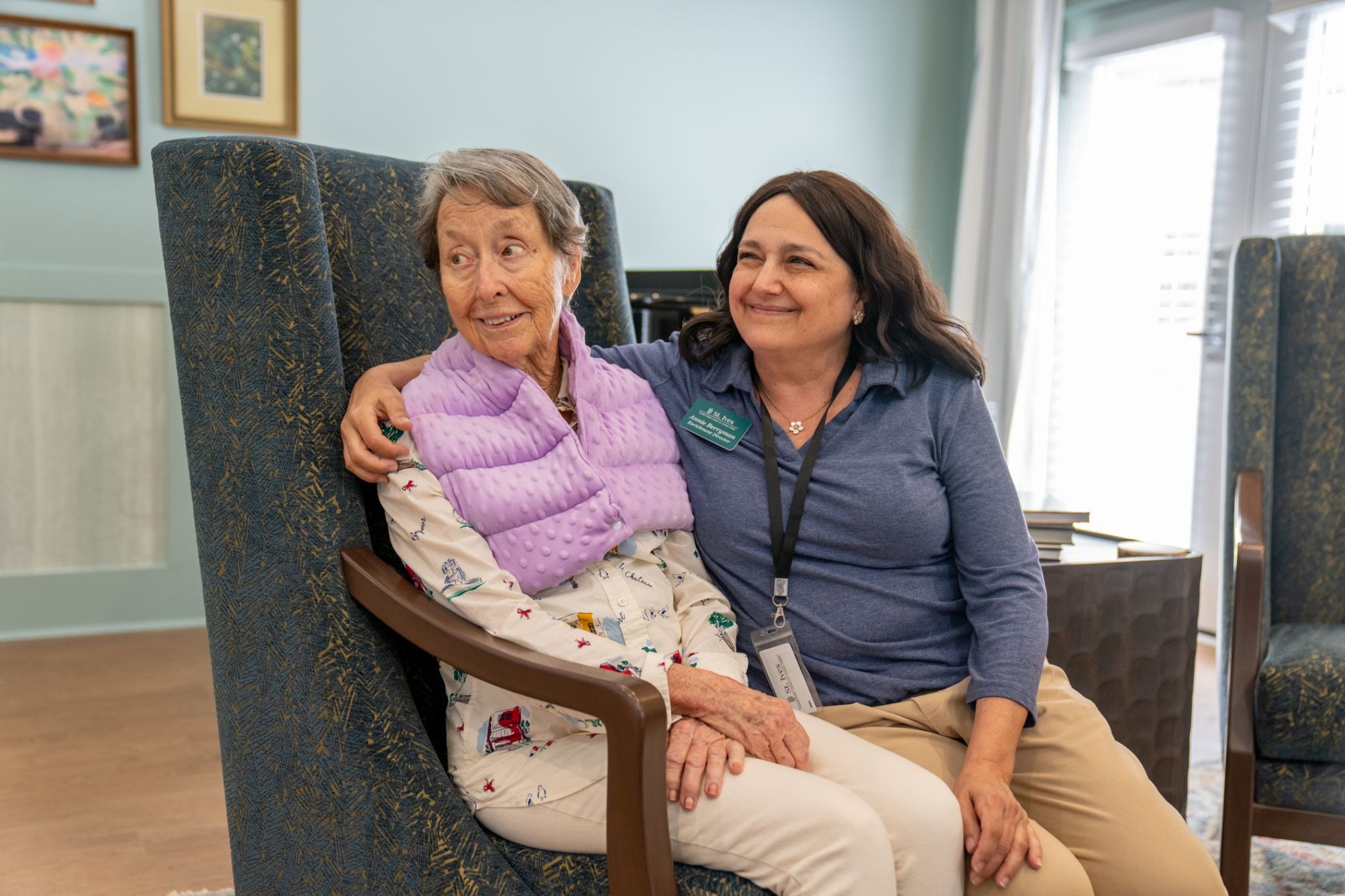 A St. Ives Hometown Living of Johns Creek team member sitting beside a resident, reflecting the compassionate support available to families navigating memory care decision guilt.