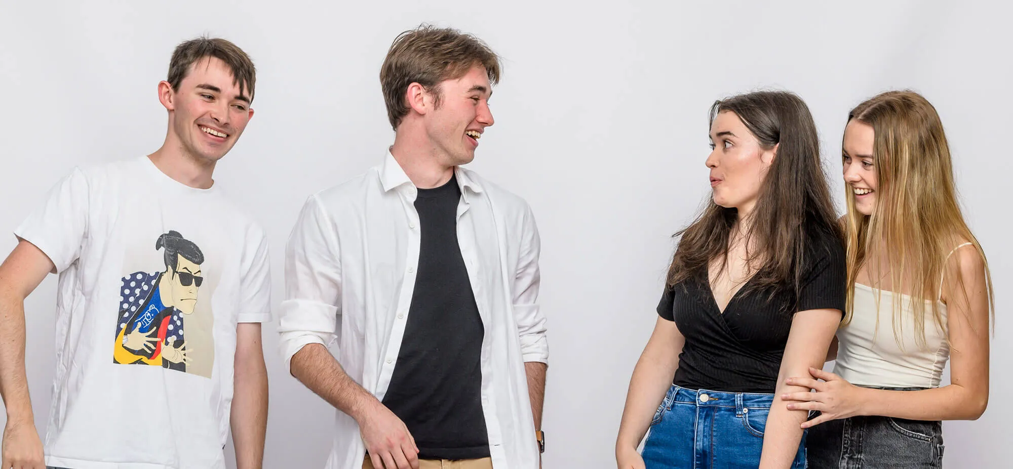 Two young adult males and two young adult females laughing together