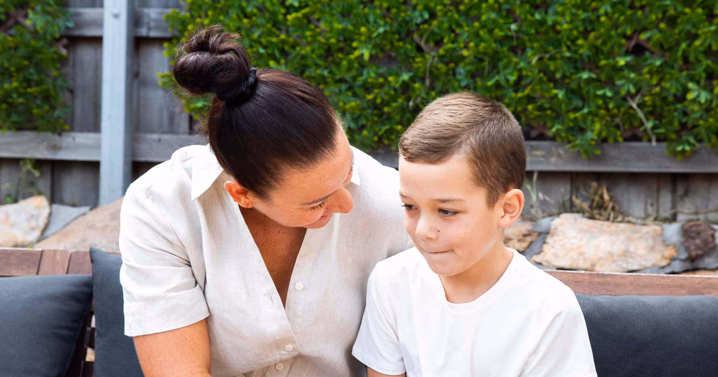 young boy talking to his mum in the garden