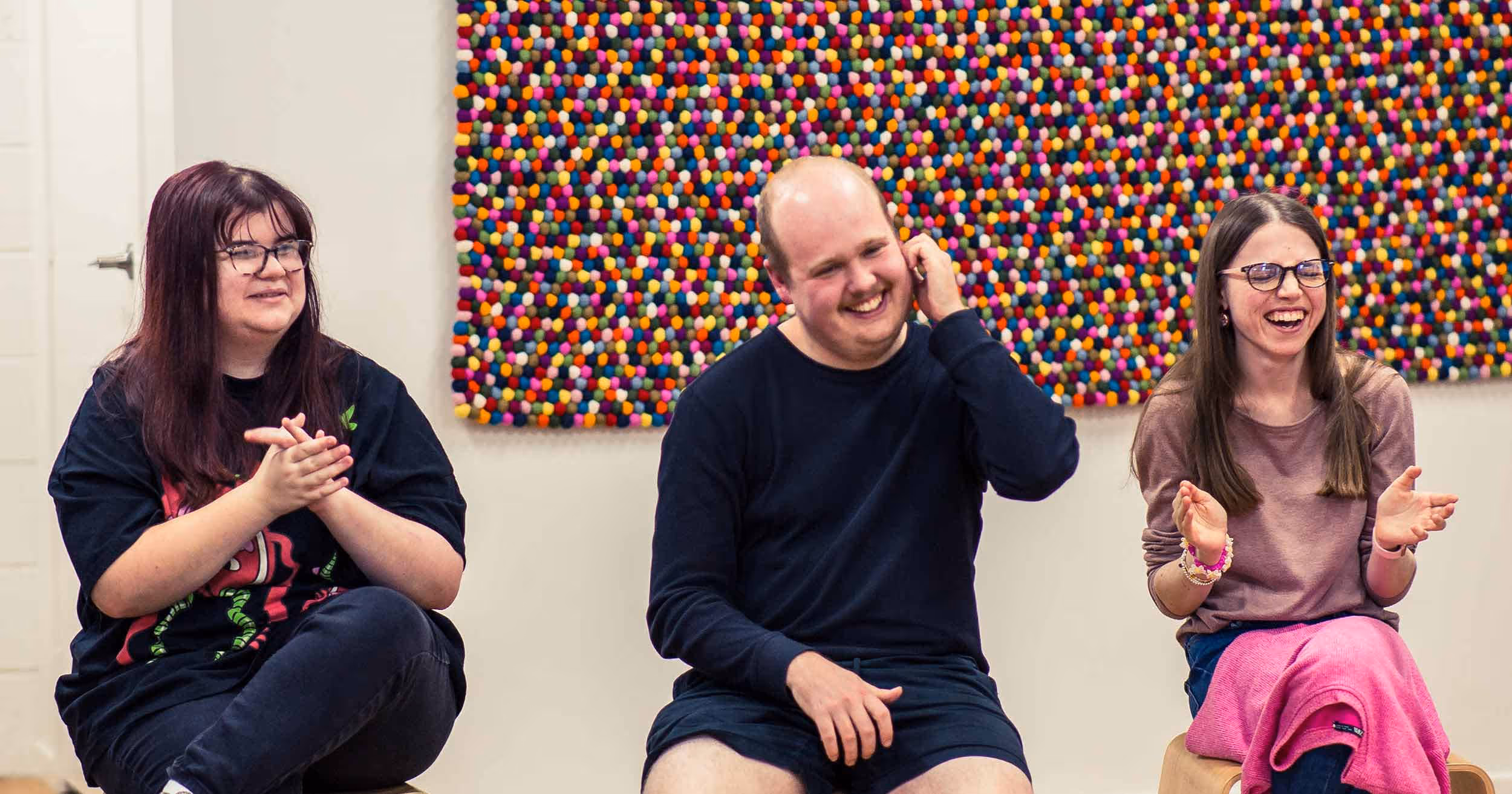 group of young adults in a workshop laughing together