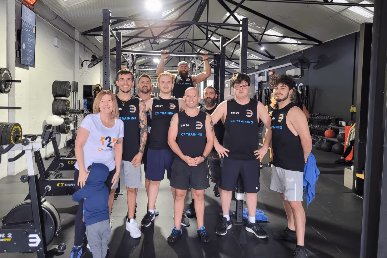 A group of autistic adults in a gym smiling.