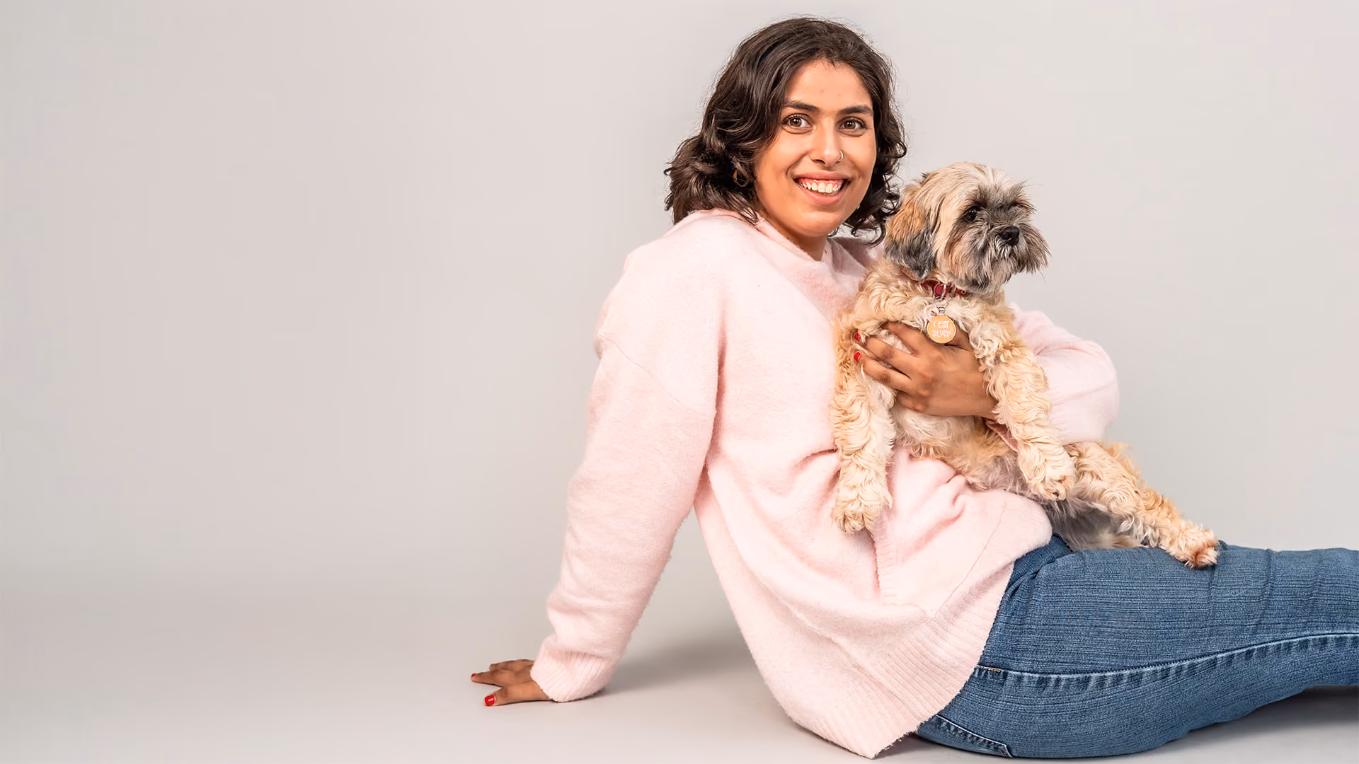 young autistic woman smiling and holding small dog