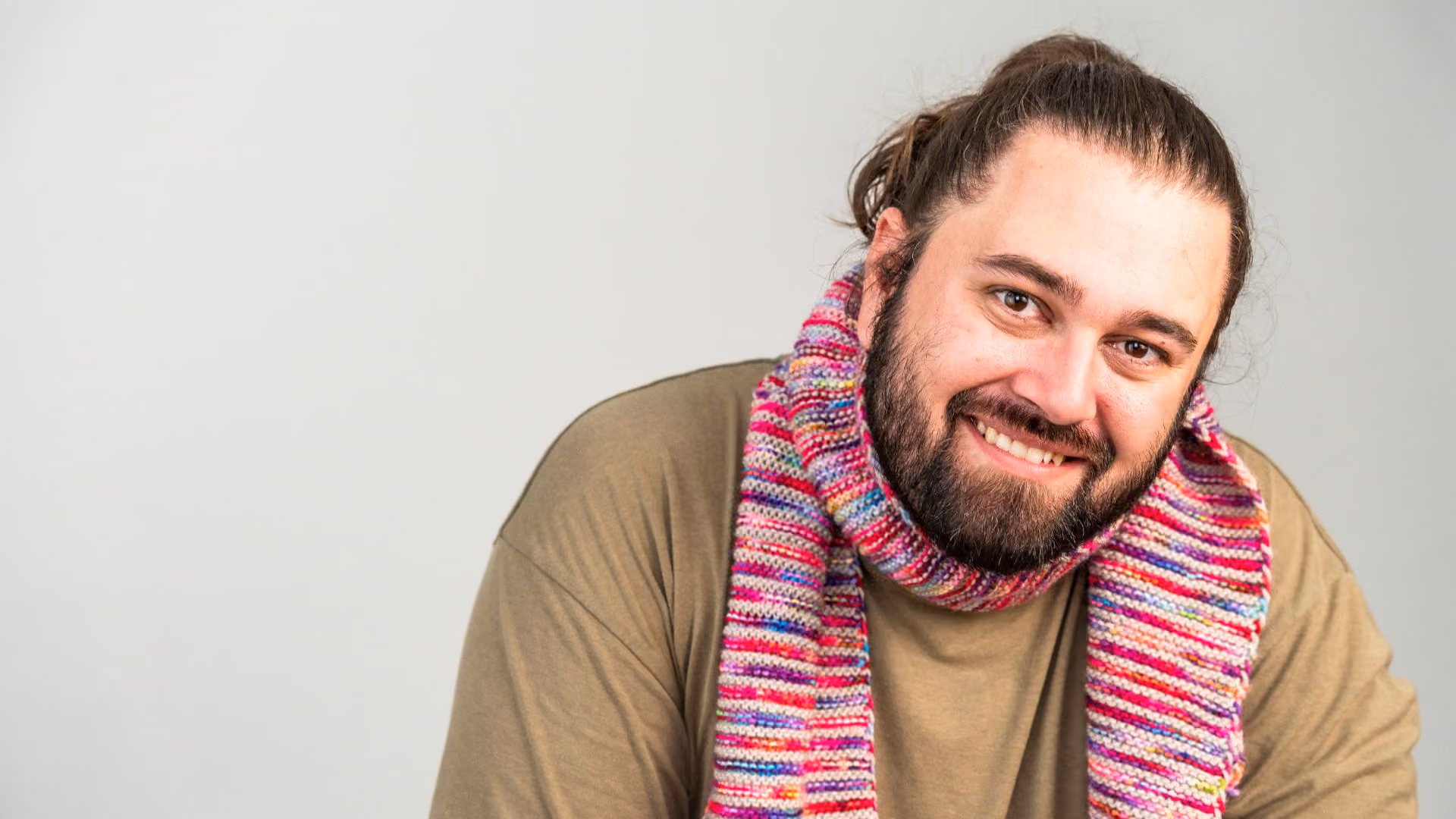 autistic man wearing scarf smiling