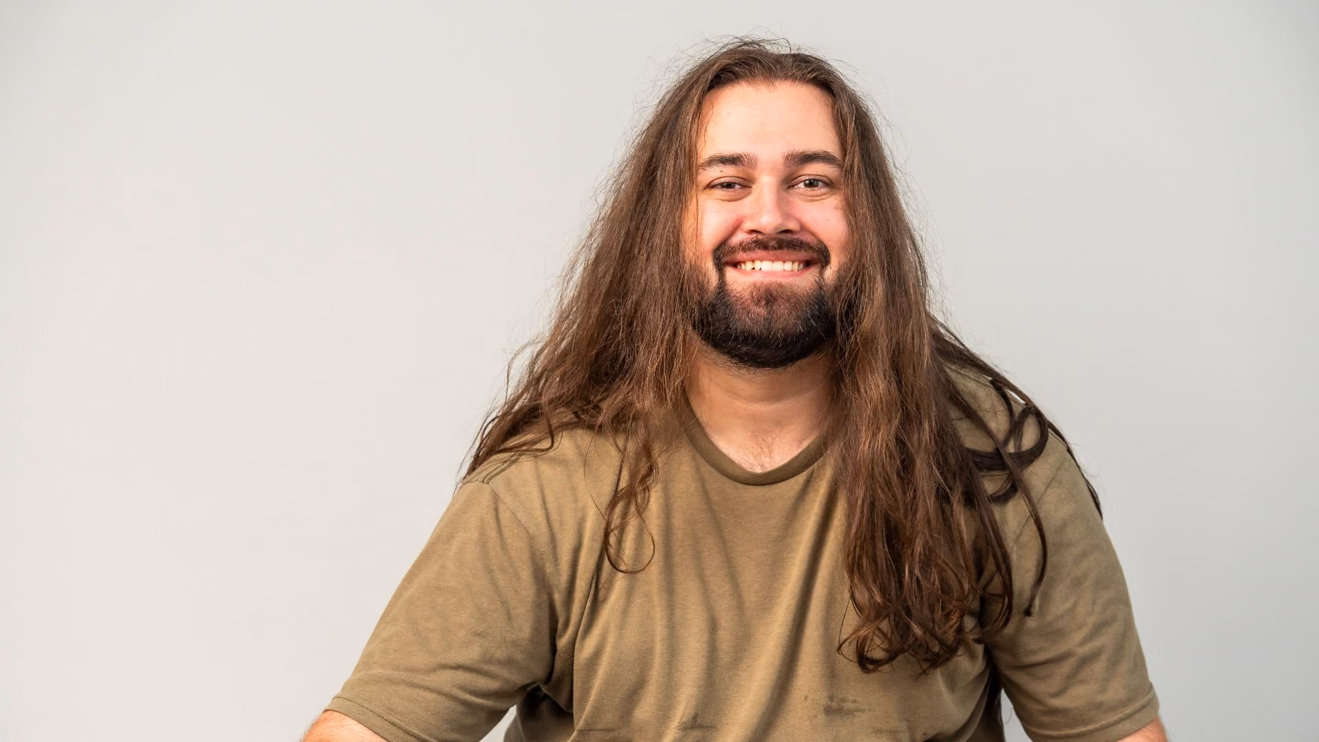 autistic man with long hair smiling