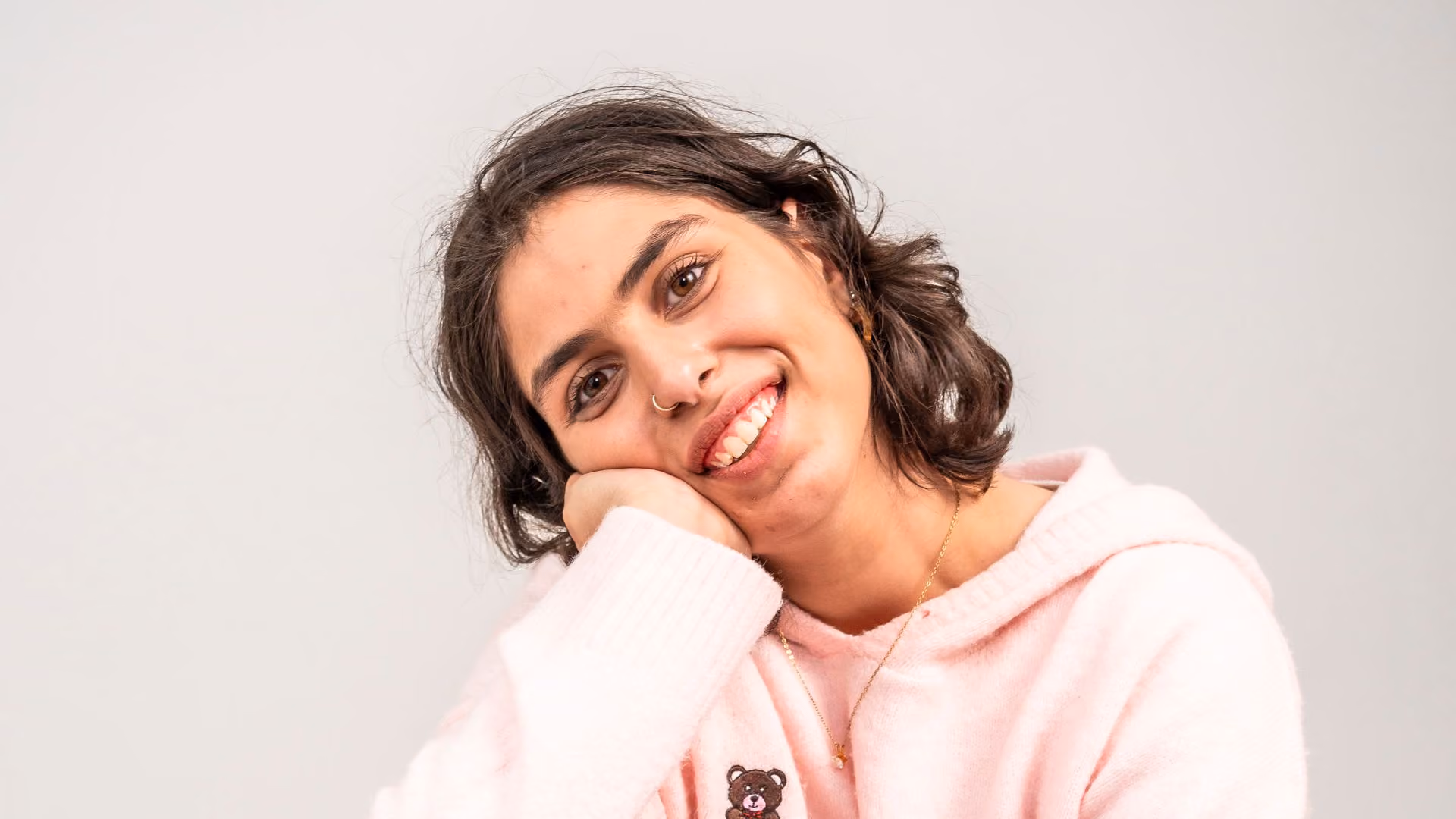 young autistic woman smiling with head in hand