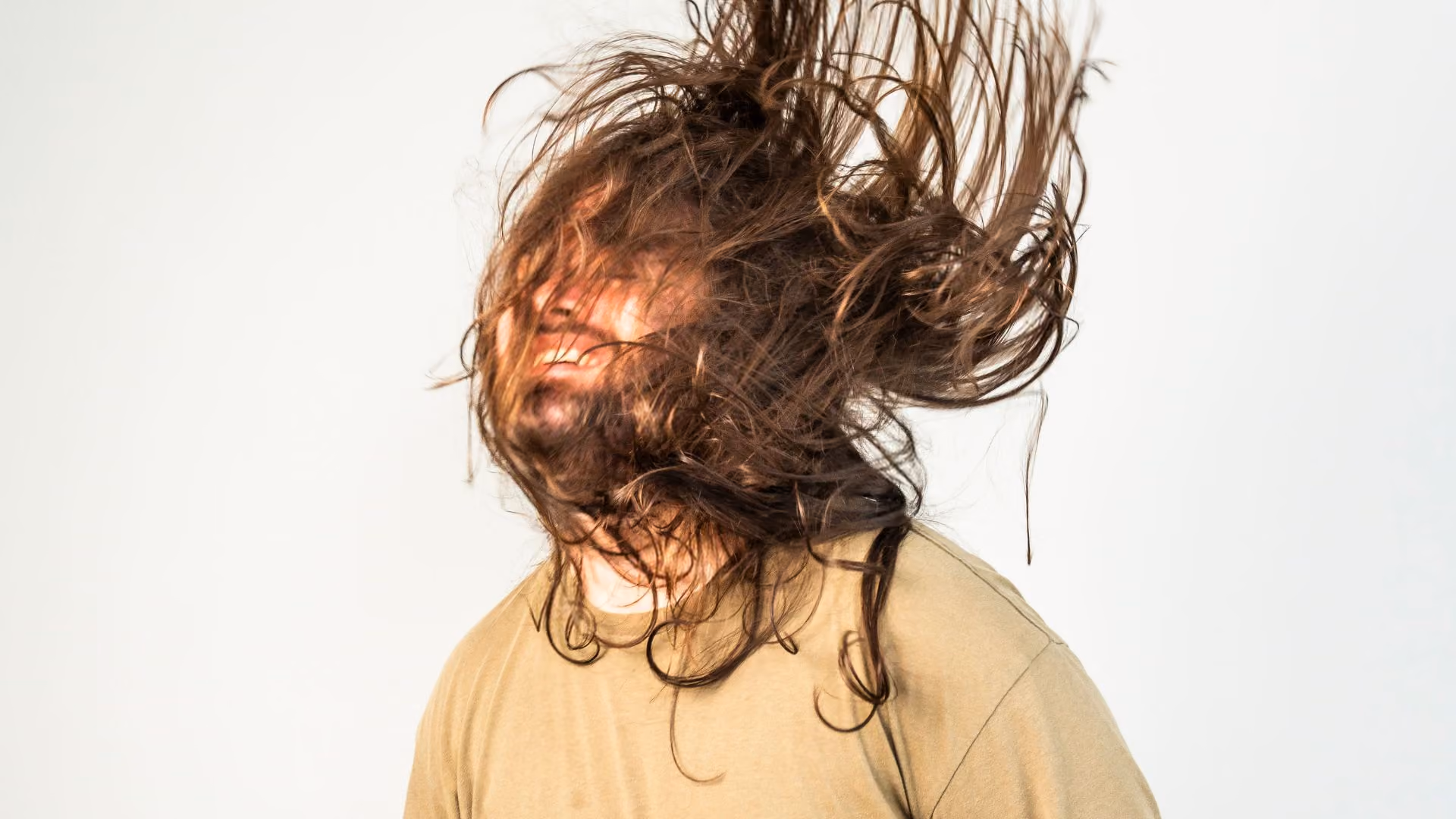 autistic man flicking his long hair over his face