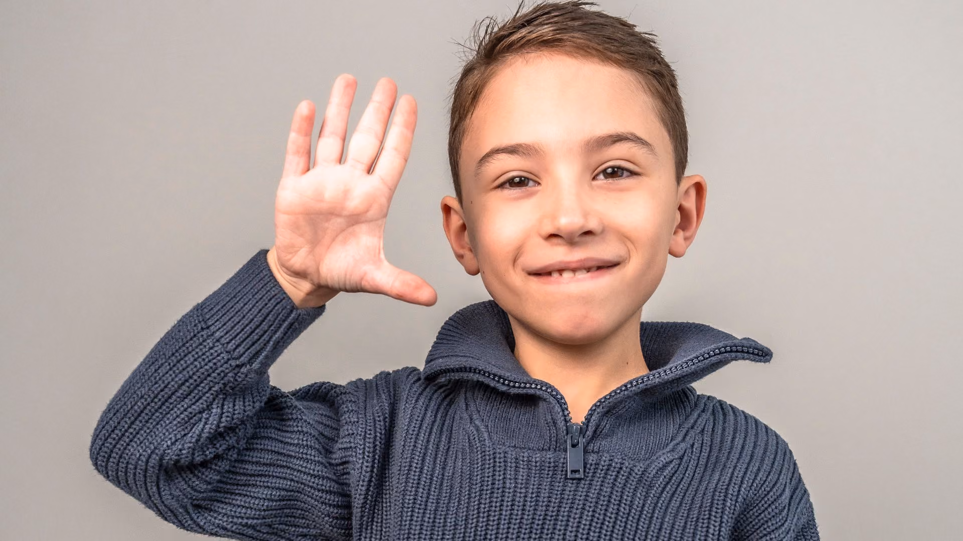 young autistic boy waving