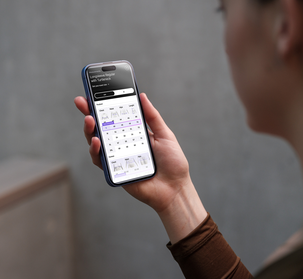Woman holding phone looking at SAIZ Chart
