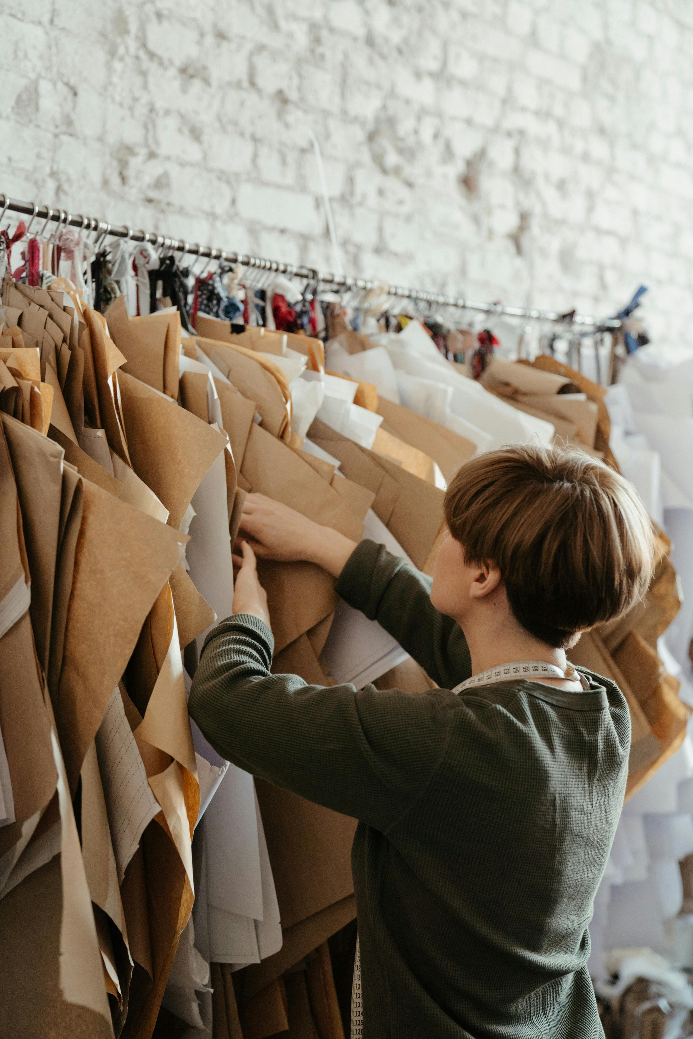 Woman going through rack of designed clothes