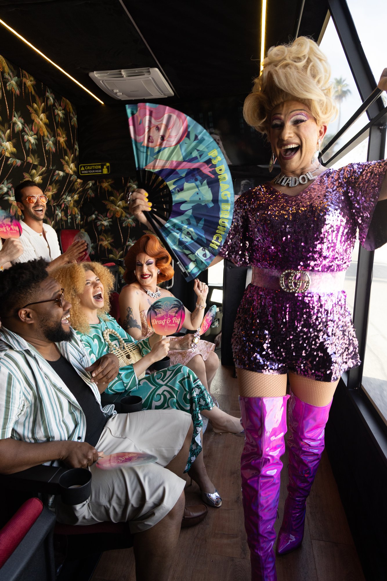 Anita Doll, drag queen host, entertaining guests aboard the Drag & Fly Tours party bus in Palm Springs