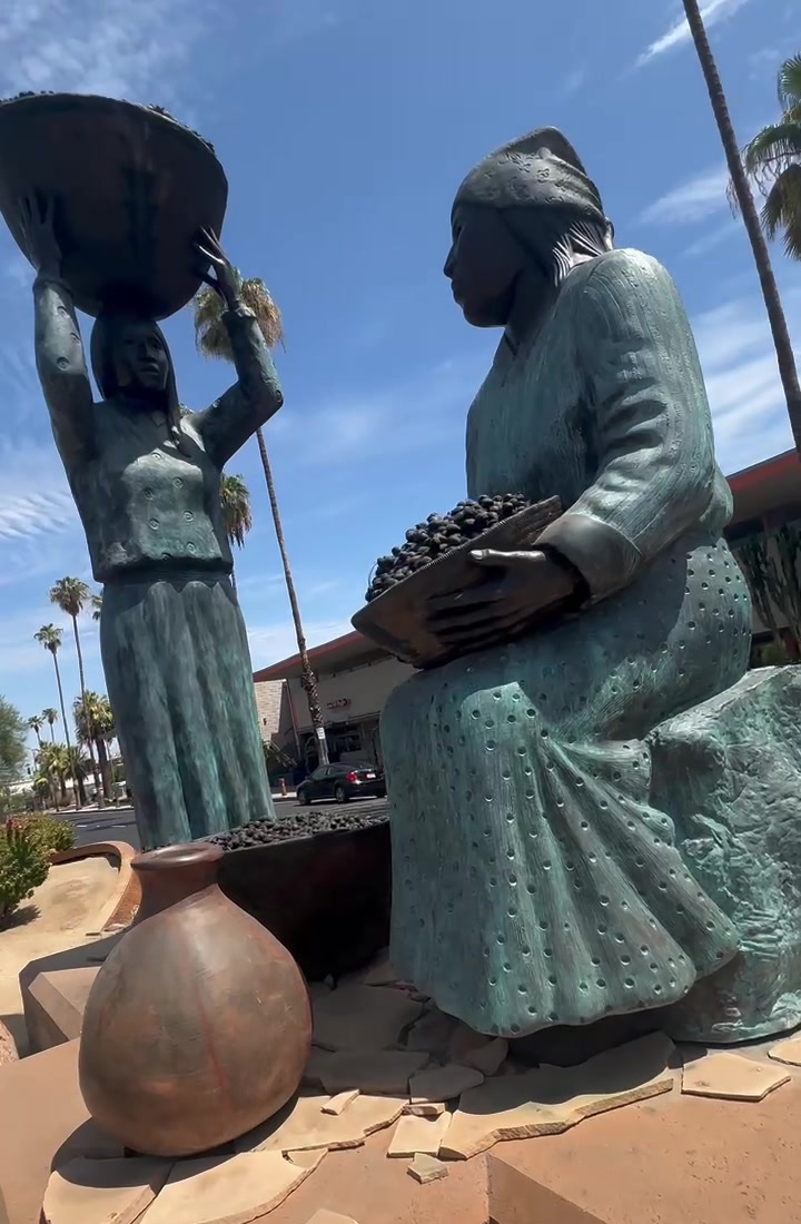 Bronze statues of two Cahuilla women with a basket, seed tray and clay pot in downtown Palm Springs
