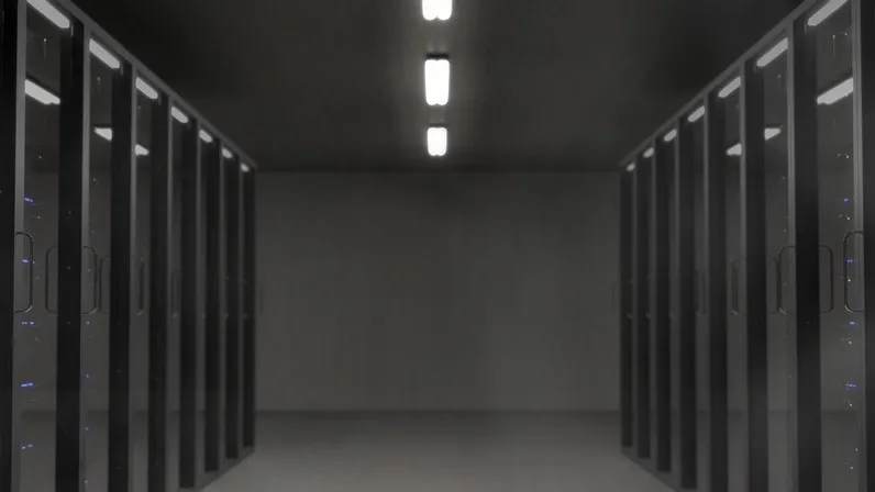 A dark server room with rows of racks on both sides.