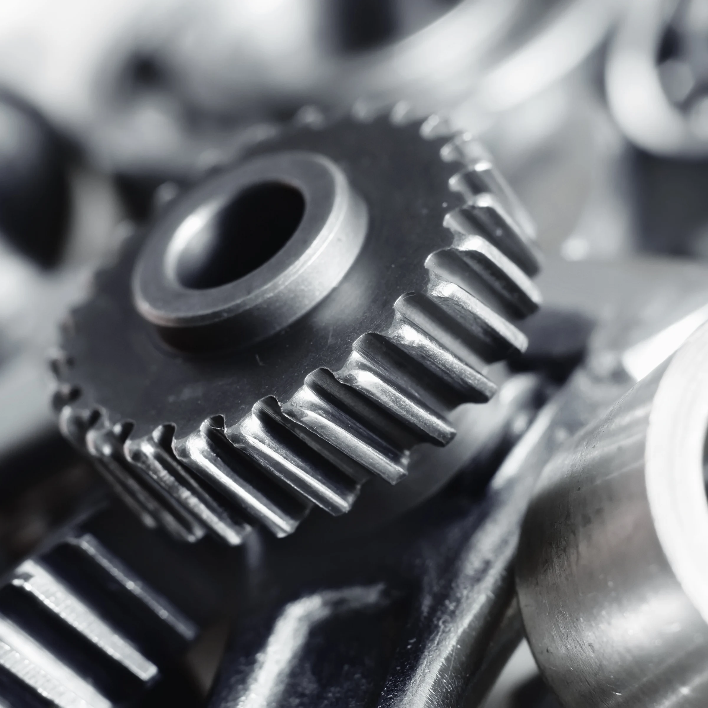 Close-up of metallic gears with detailed teeth interlocked in a mechanical assembly.