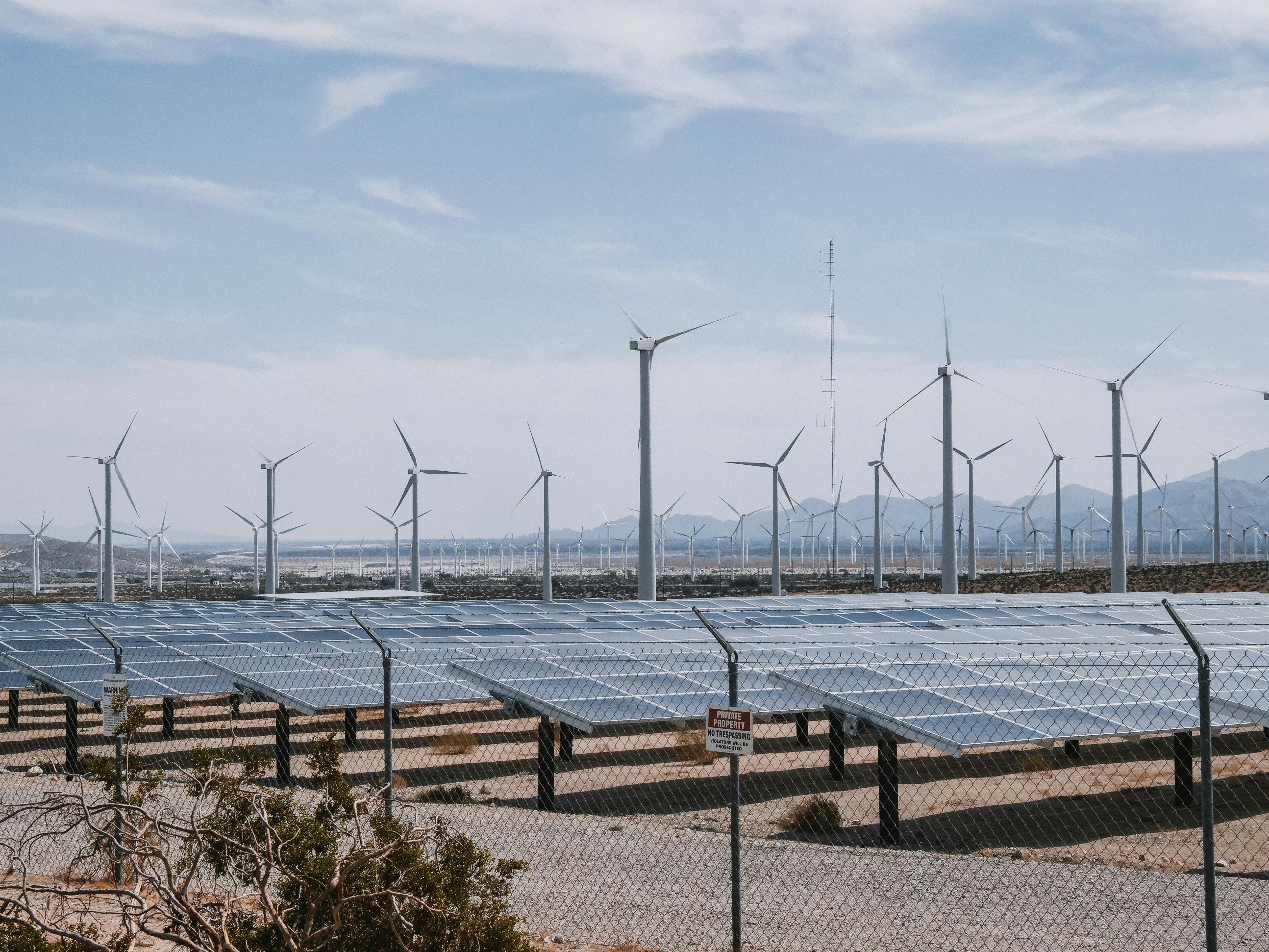 A solar farm in front of a wind farm built with project management