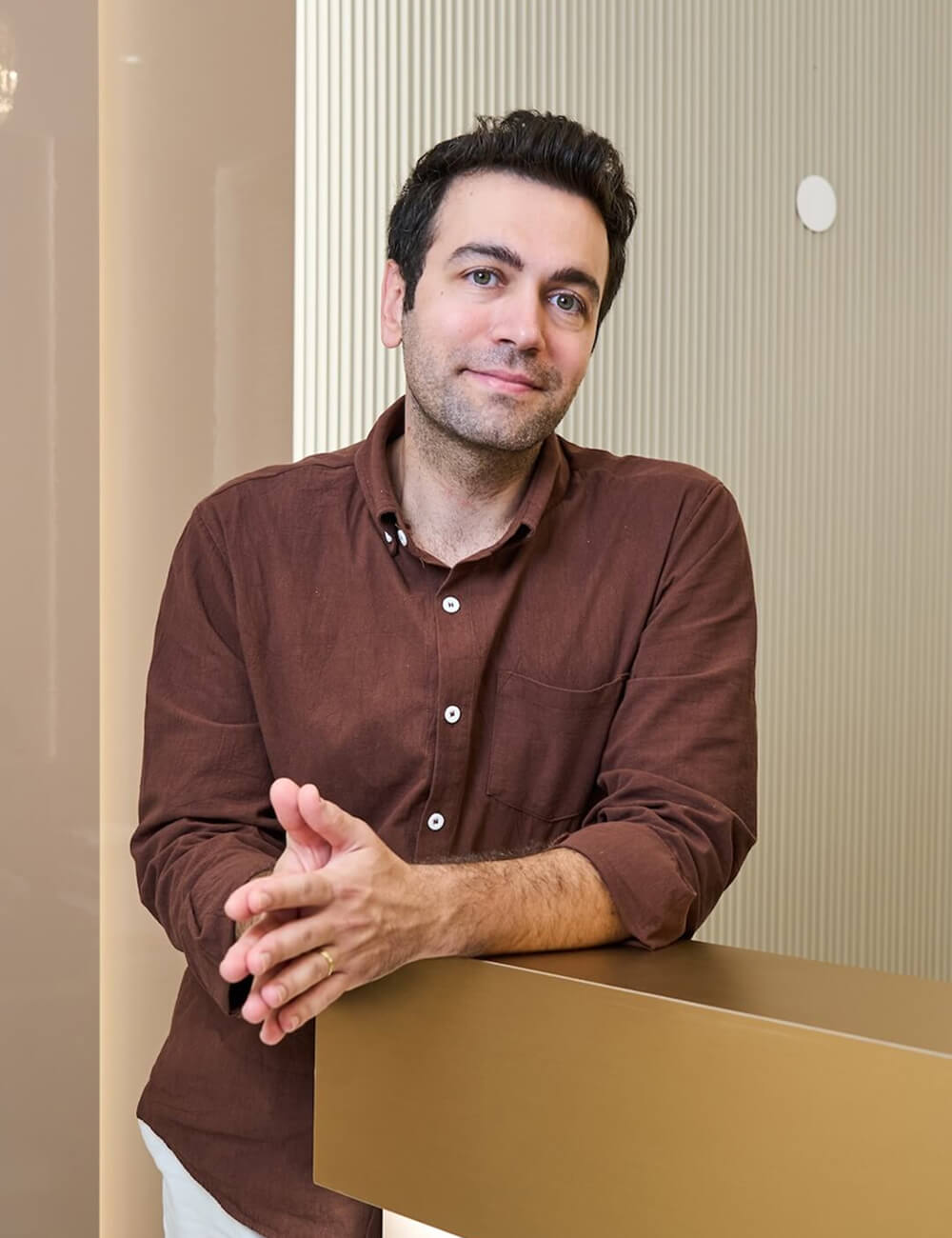 Dr. Gökhan Baris standing by a desk 