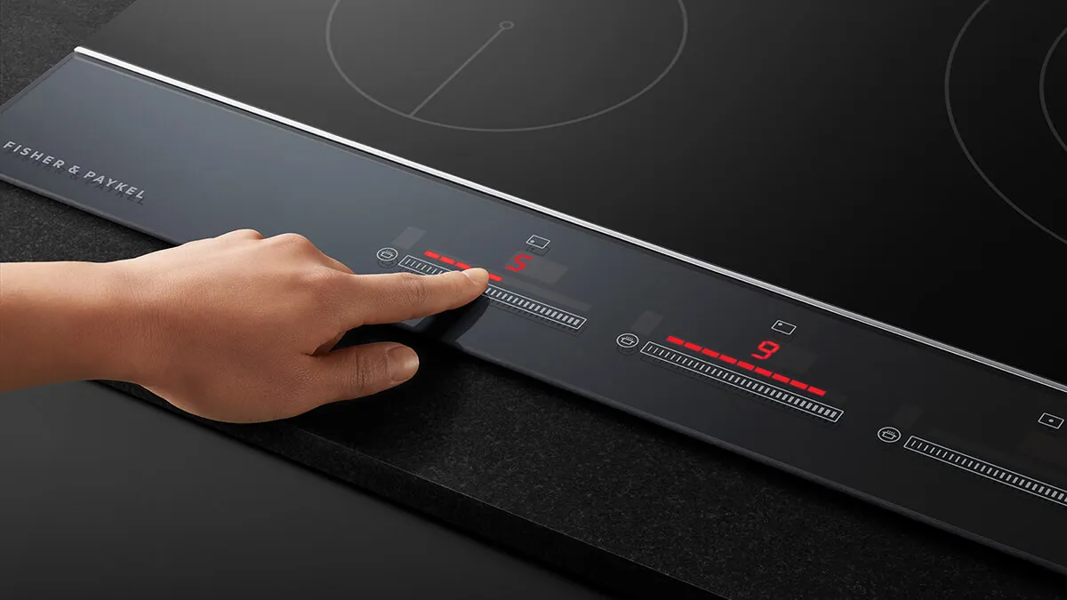 Hand turning on a touch cooktop
