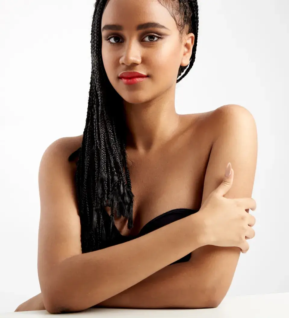 a woman with long braids is posing for a picture