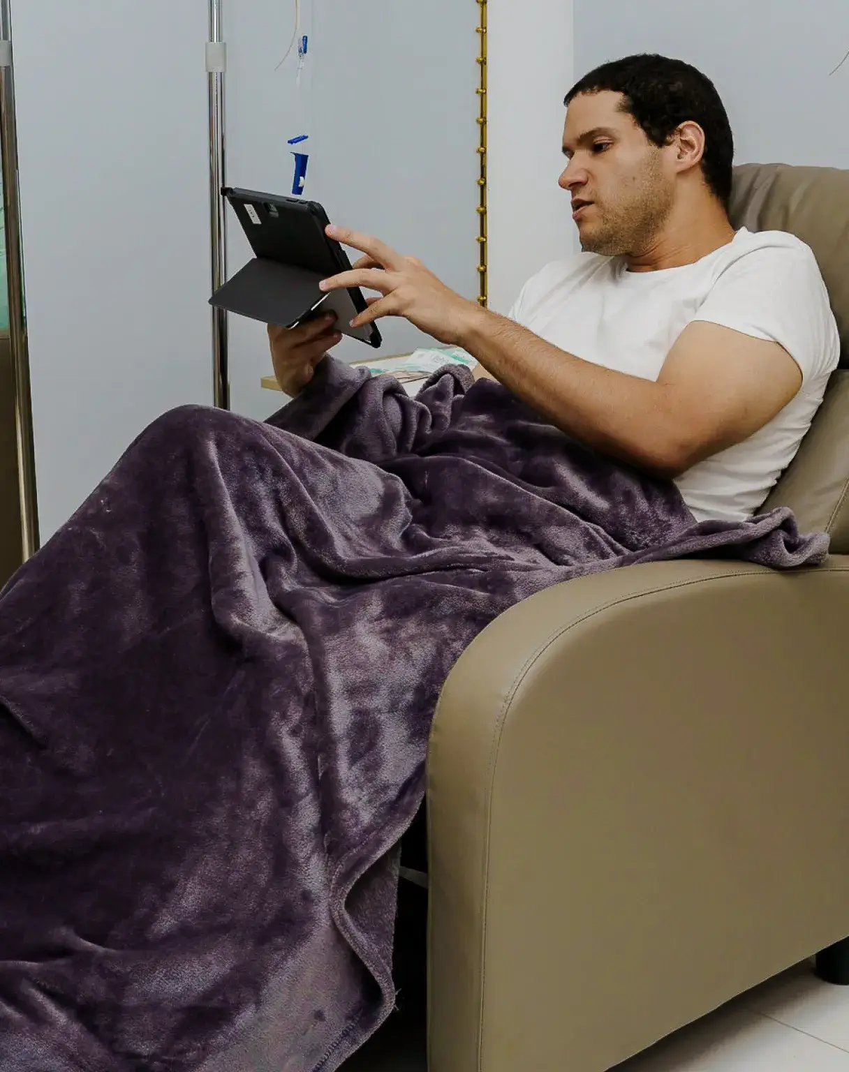 a man sitting in a chair holding a tablet