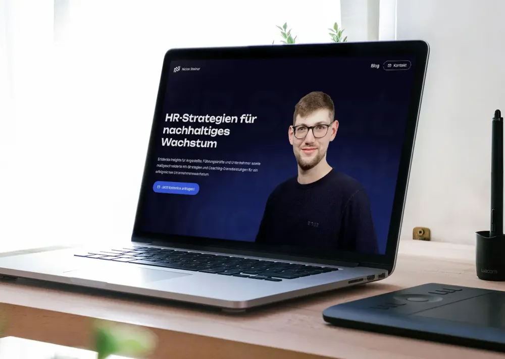 Laptop auf einem Schreibtisch zeigt eine Webseite mit der Überschrift 'HR-Strategien für nachhaltiges Wachstum' und einem Porträt eines Mannes.