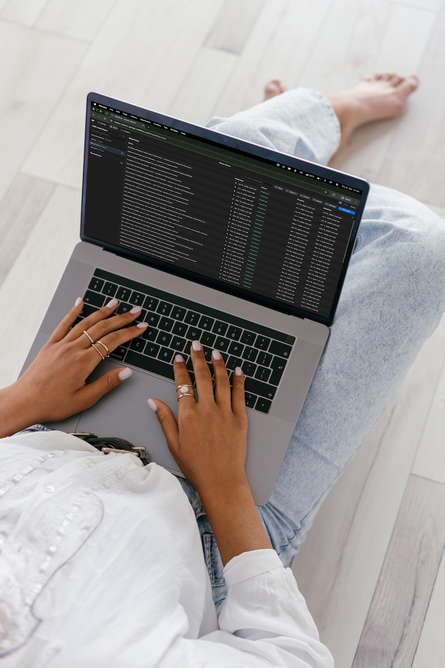 Hände tippen auf einem Laptop, auf dem Bildschirm eine Liste veröffentlichter Beiträge im Webflow-CMS