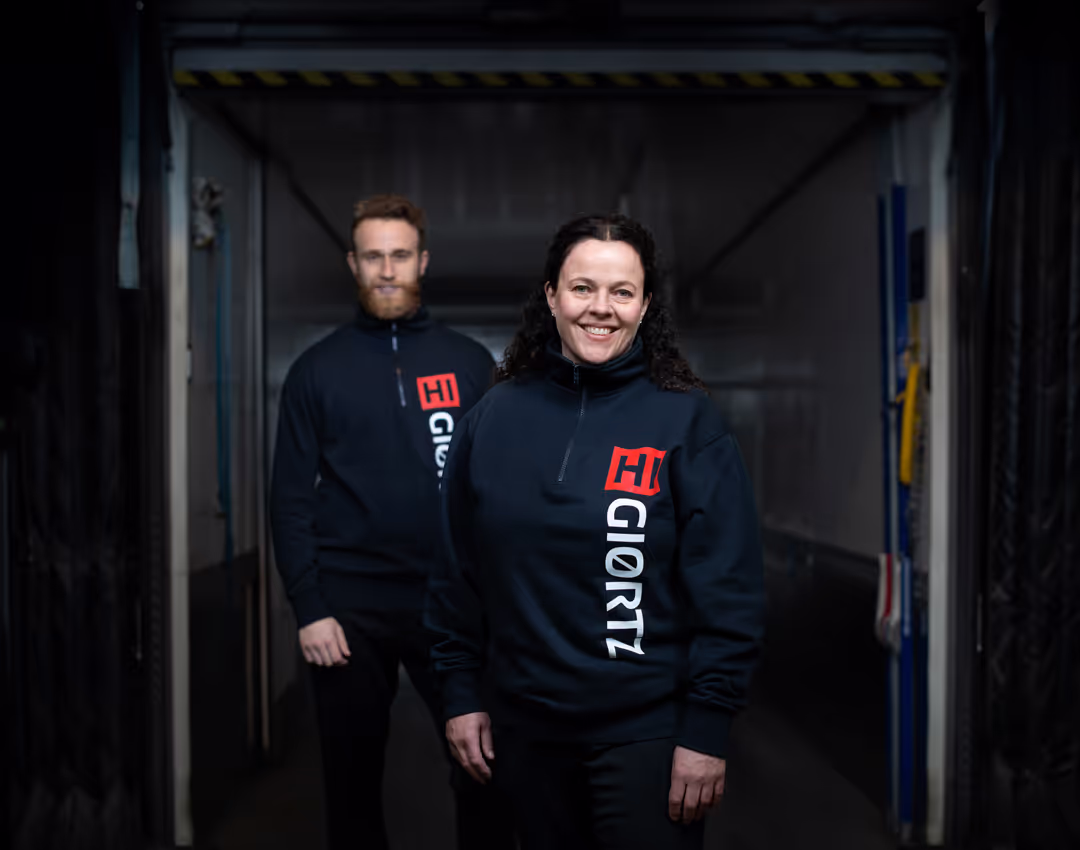 Lagermedarbeidere ser i kamera.