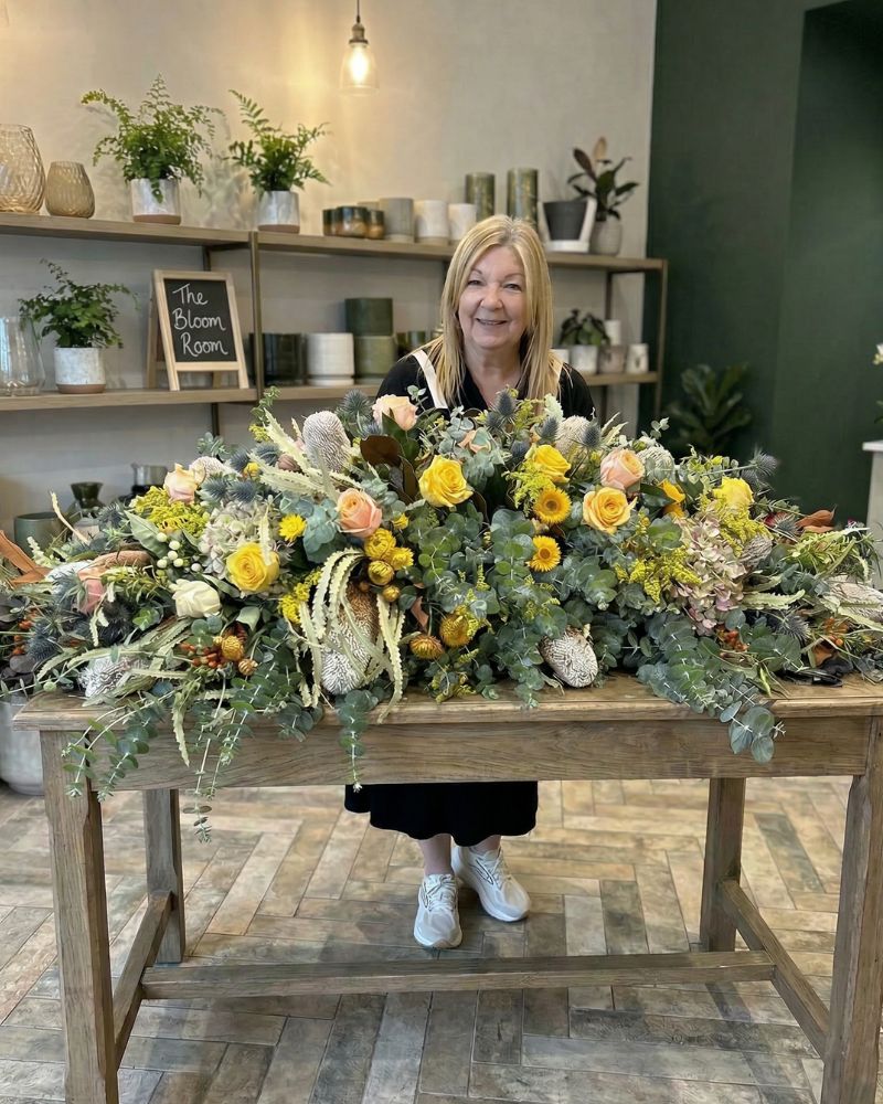 Val arranging a tribute at her workbench in Mornington