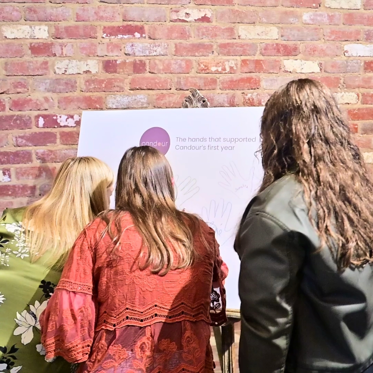 Guest adding their name to the hands that shaped Candour's first year