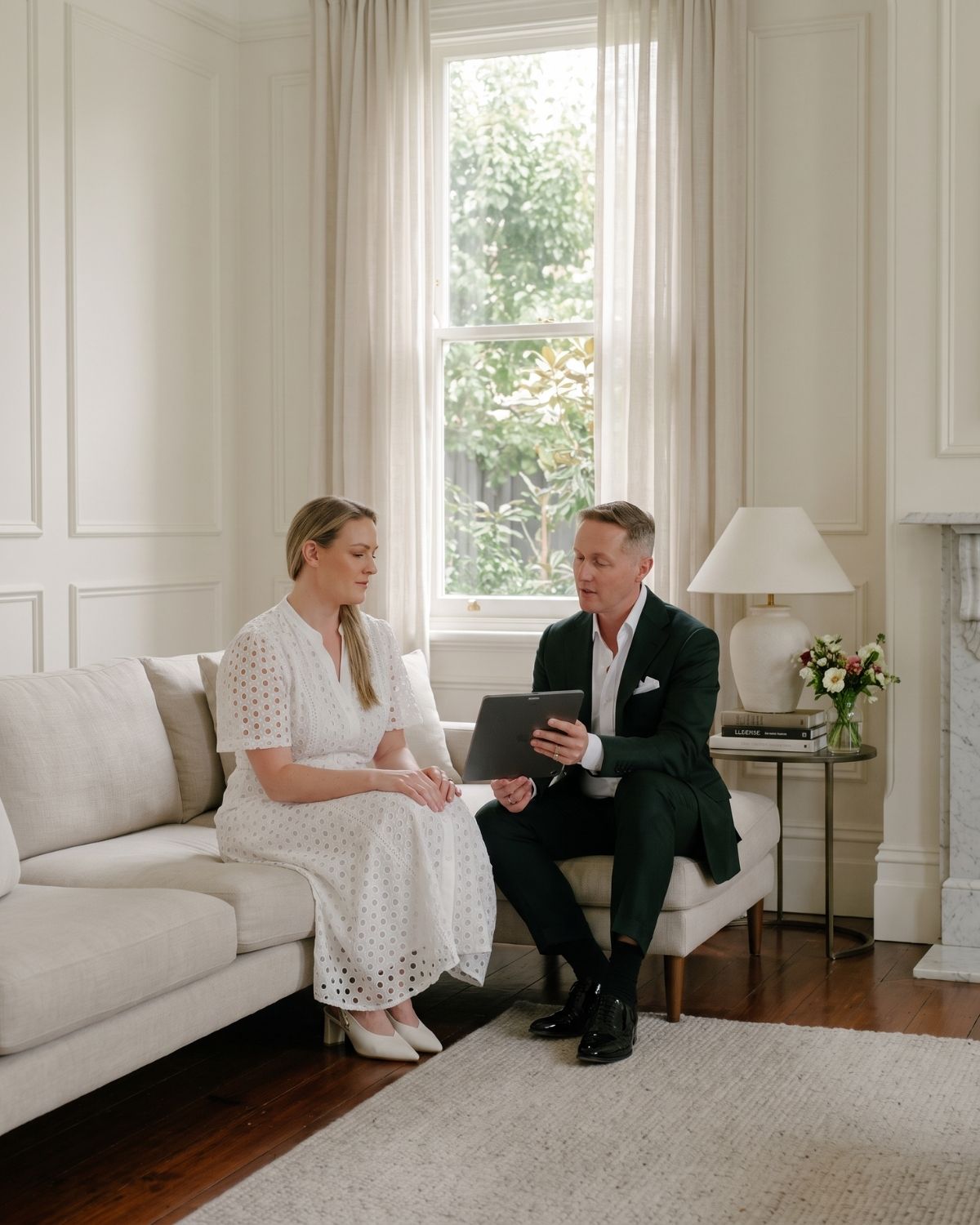Simon and Sameiko from Candour in quiet conversation over an iPad in a warm family living room