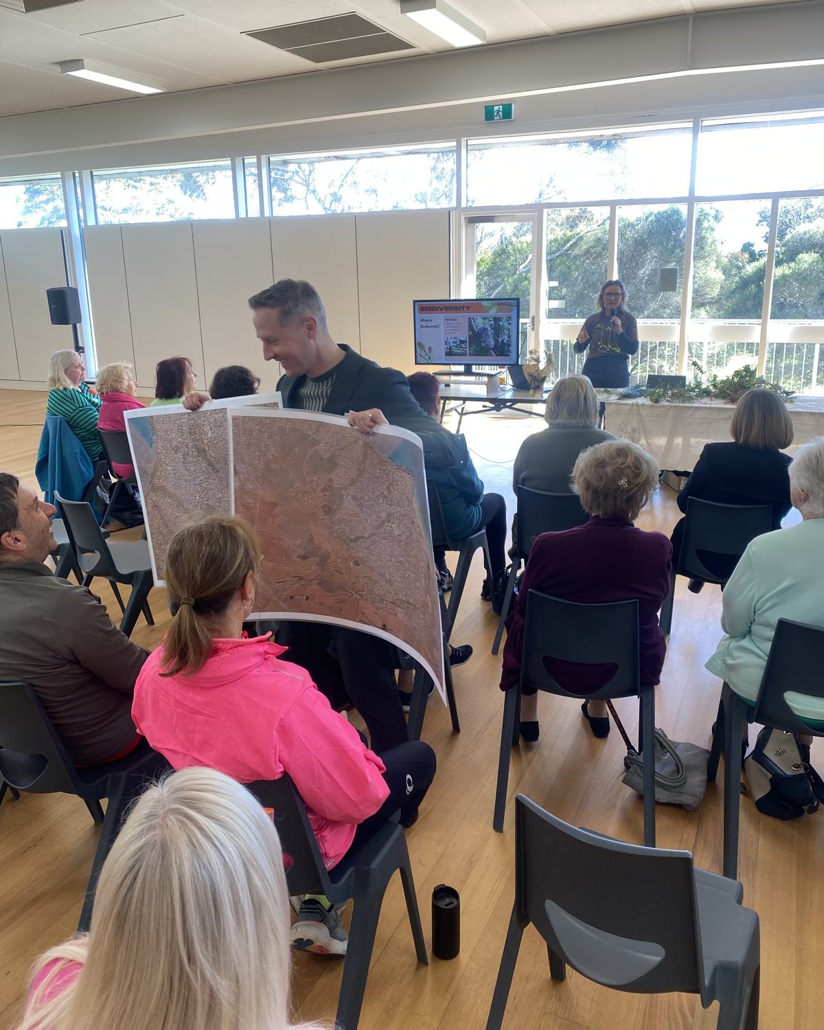 Simon holds up aerial maps of the Peninsula during a Naturelinks talk on local biodiversity
