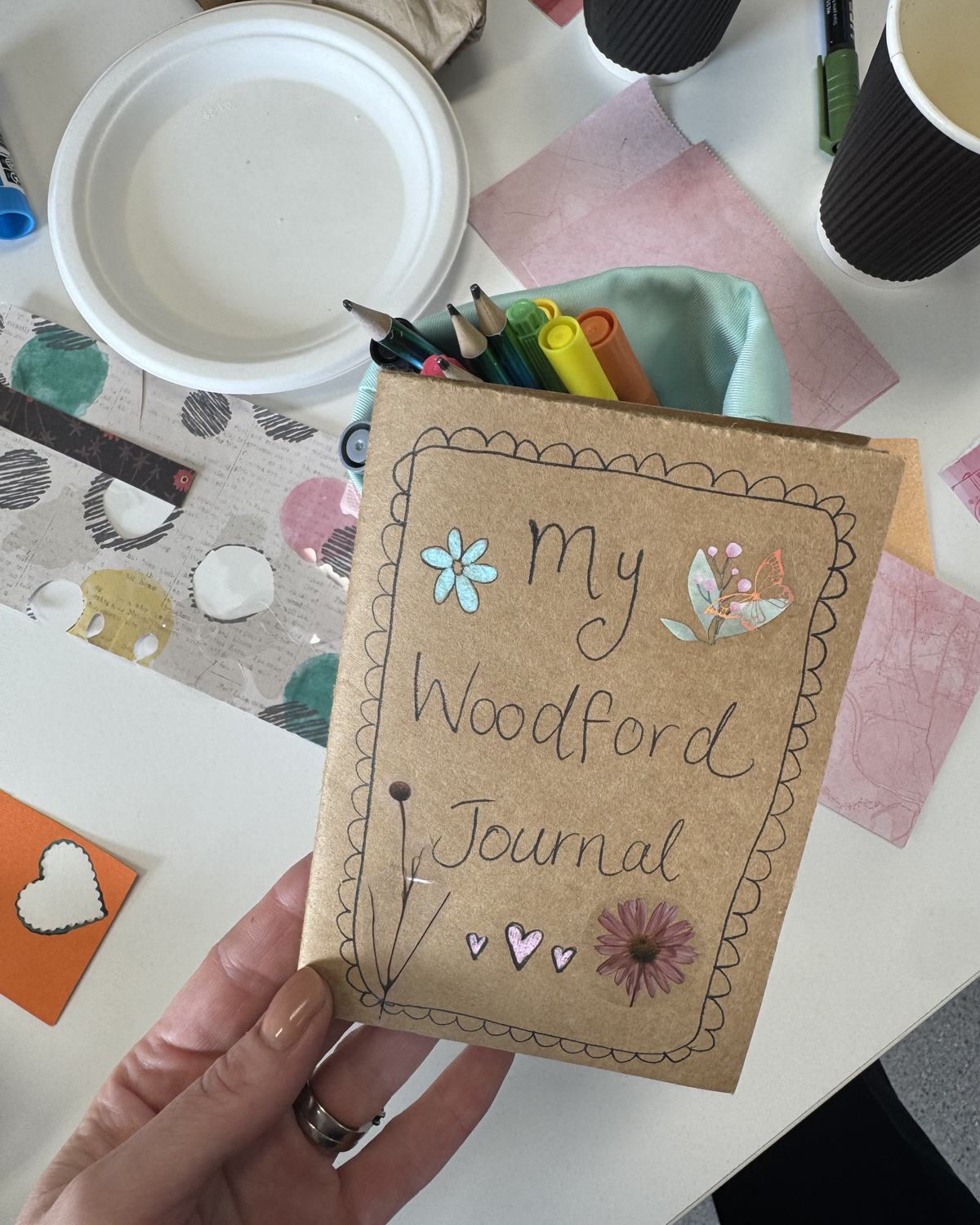 A hand-decorated journal with pressed flowers, made at our Biggest Morning Tea junk-journalling session