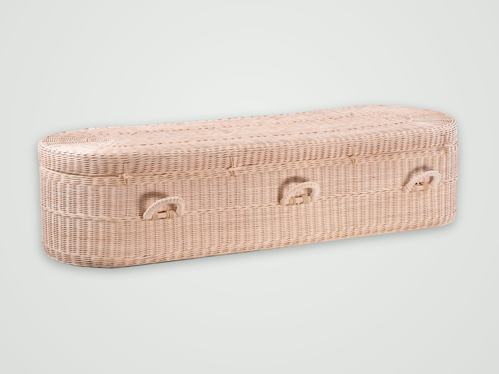 A pale woven willow casket with rounded ends and hand-woven handles