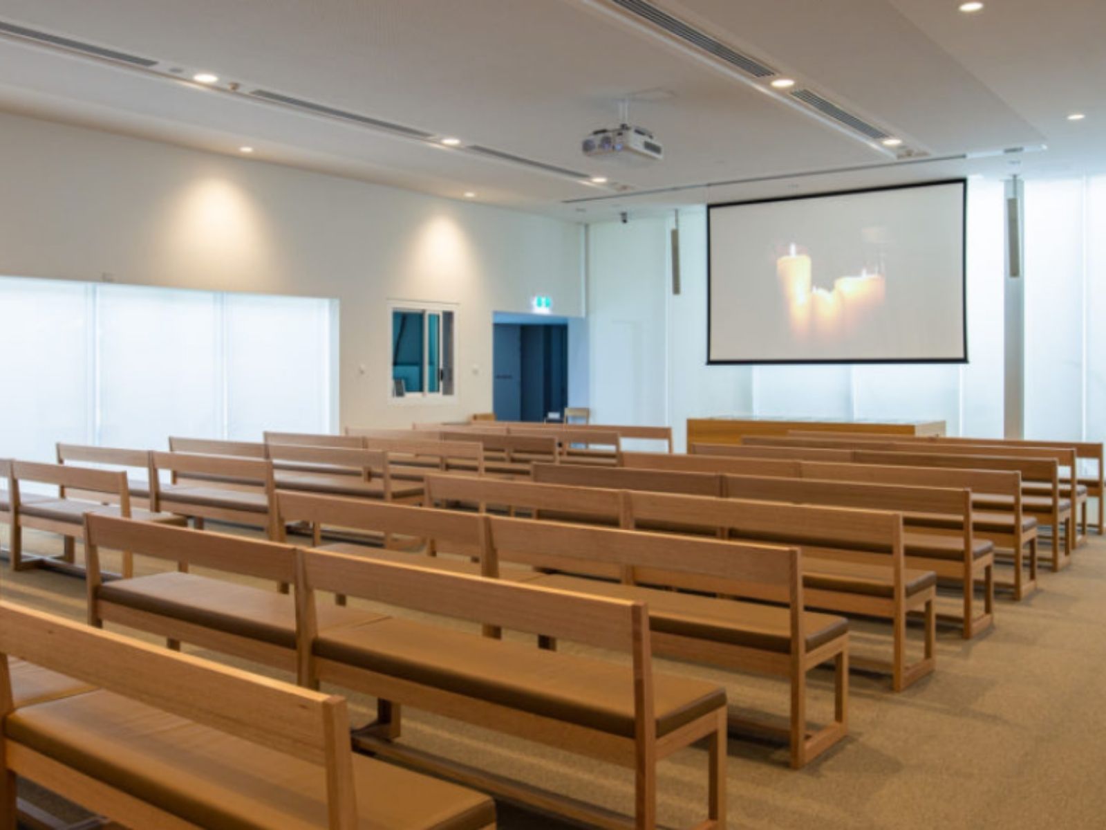 Inside cumulus chapel showing empty seats and projector