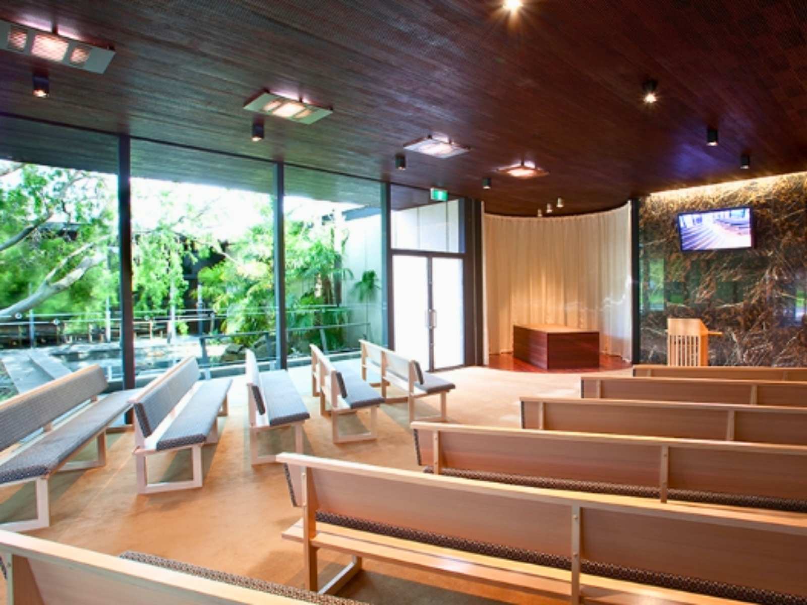 Inside Blair Chapel at Springvale Botanical Cemetery. View of the garden through full height glass windows
