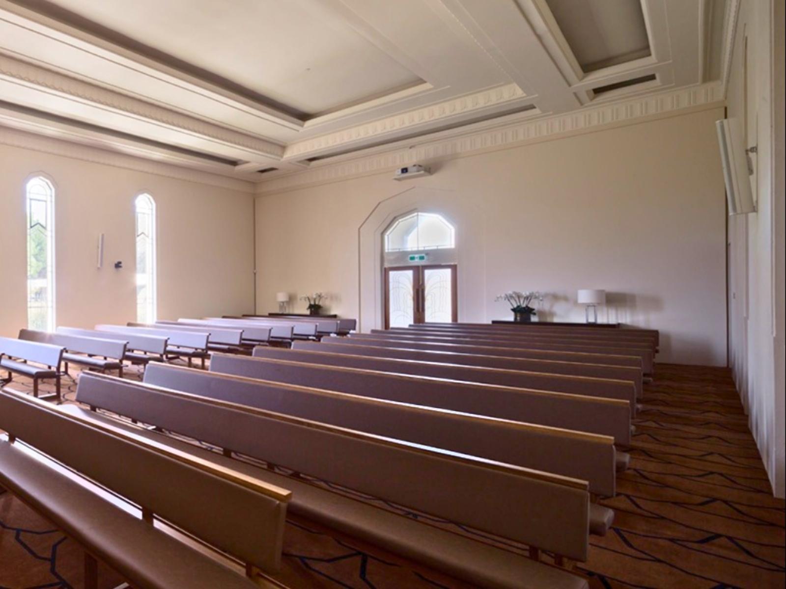 Rows of empty pews inside the large Boyd reflection space and chapel at Springvale Botanical Cemetery