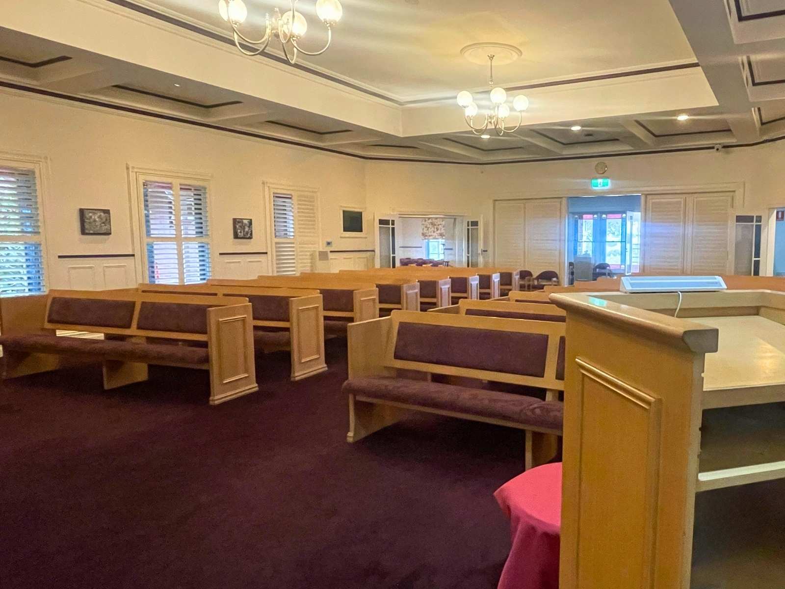 Inside federation chapel at Lilydale Memorial Park. Empty pews and inset ceilings.