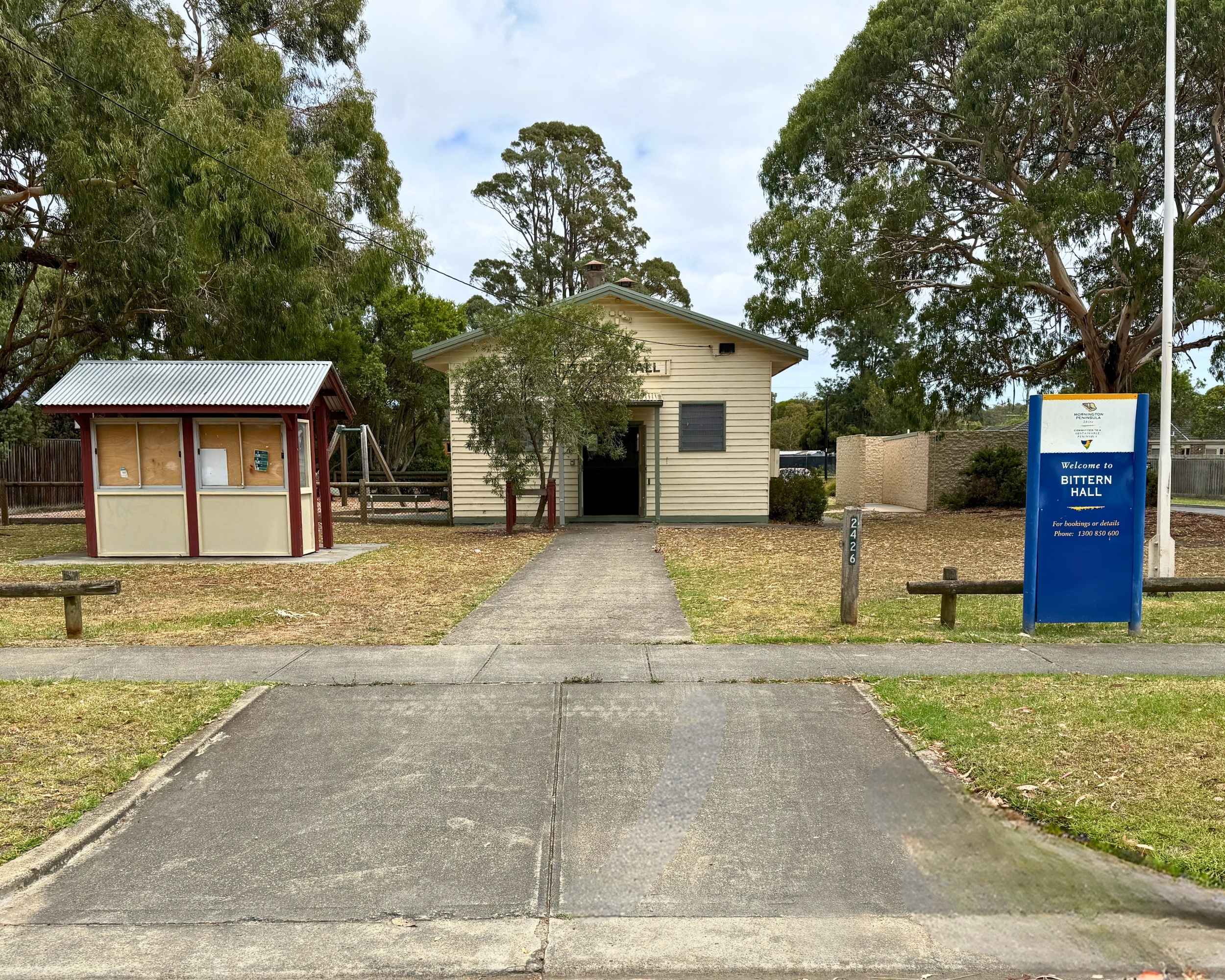 Exterior view of Bittern Hall showing the entrance path, surrounding trees, and signage.