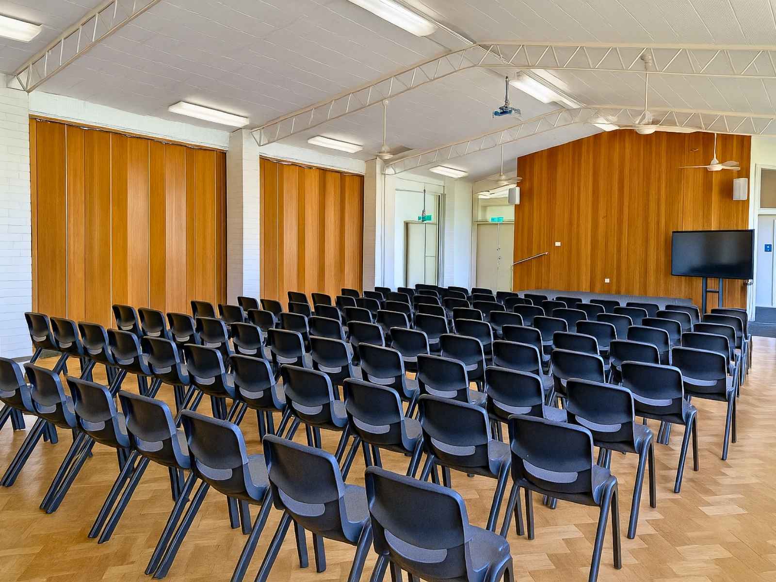 The hall is arranged with black chairs in rows, ready for a community event or ceremony.