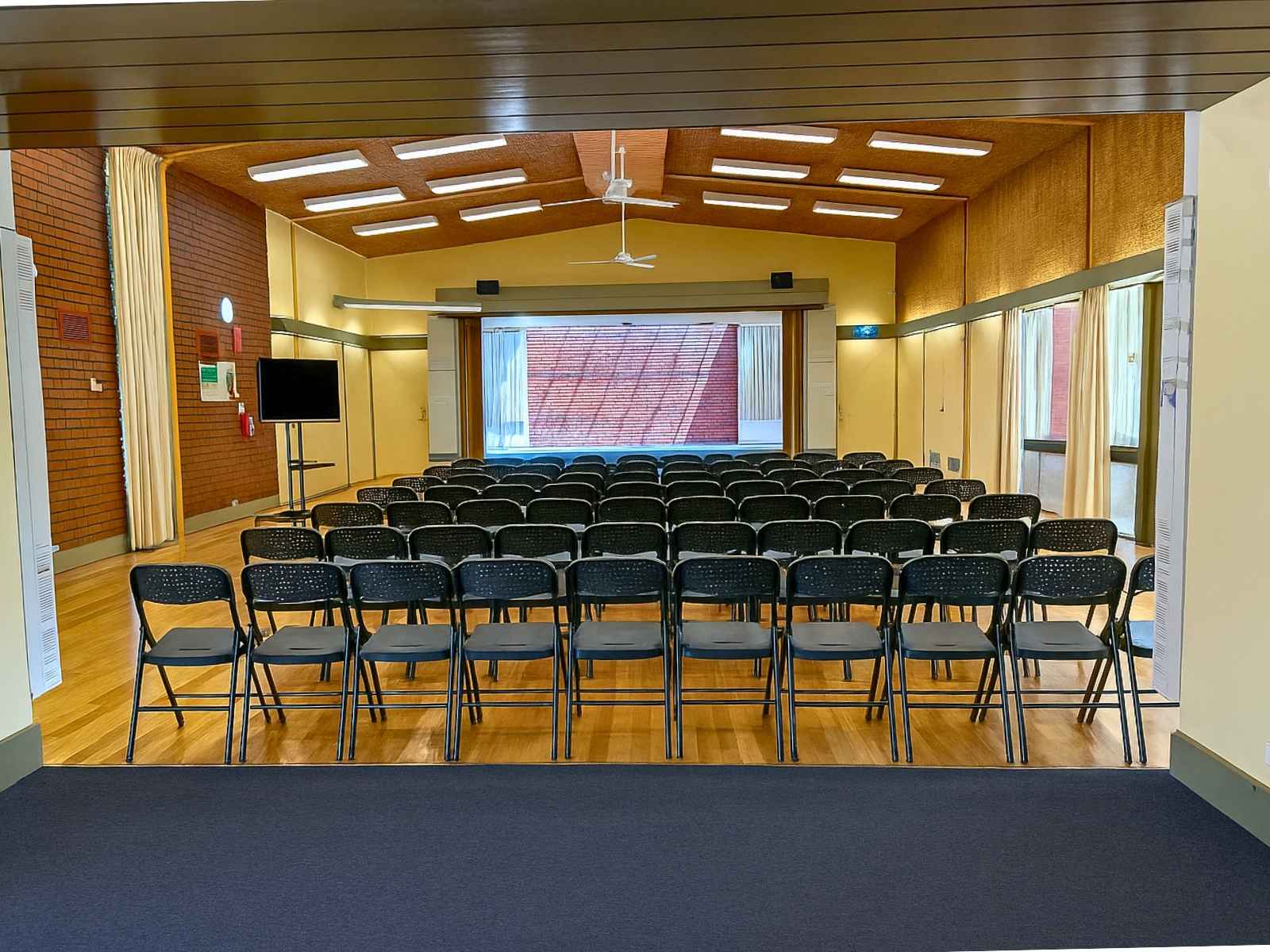 Straight-on view of the stage and seating area in the main hall, showing a wide and bright interior.