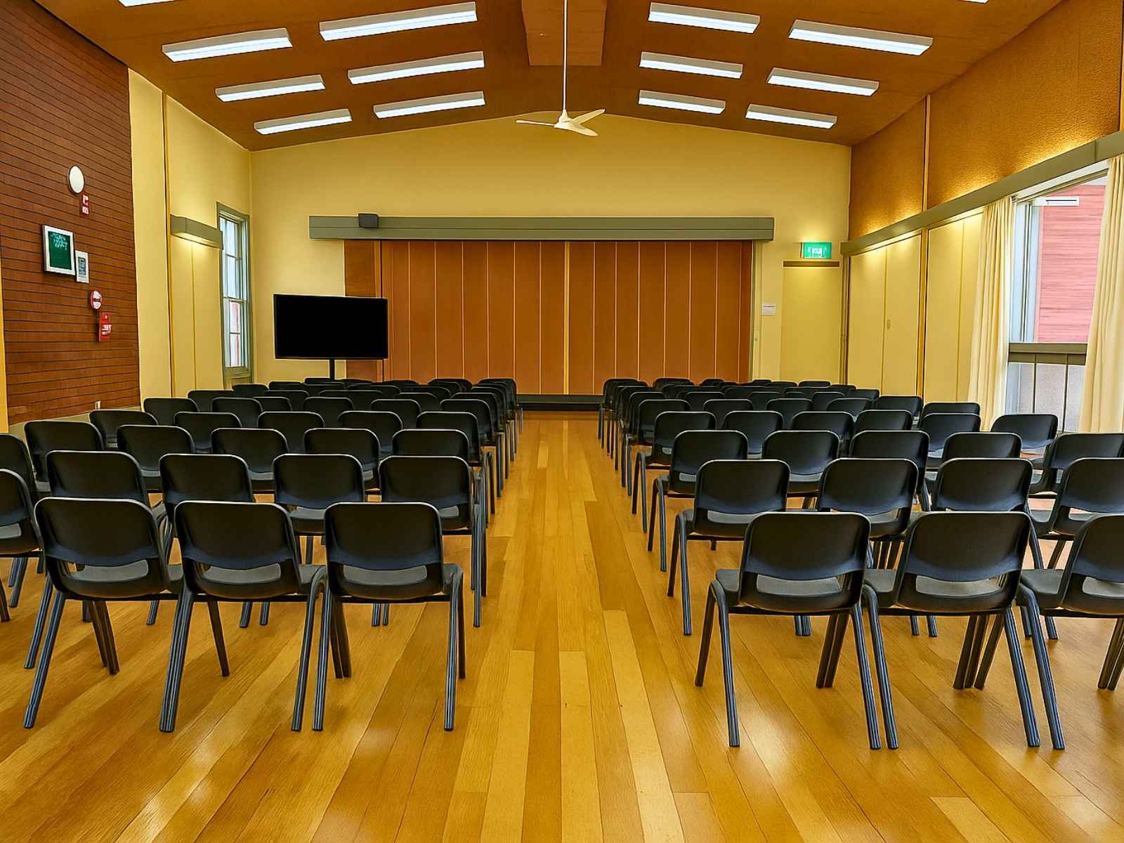 Seating configuration with a centre aisle in the main hall, highlighting the ceiling design and side windows.