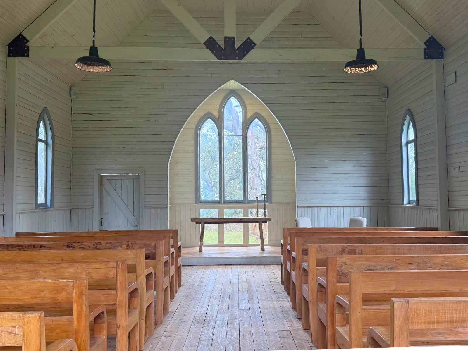 Tanglewood Estate inside the beautiful 100 year old chapel with custom wooden pews and beautiful high ceiling features. LIght shining through curved windows.