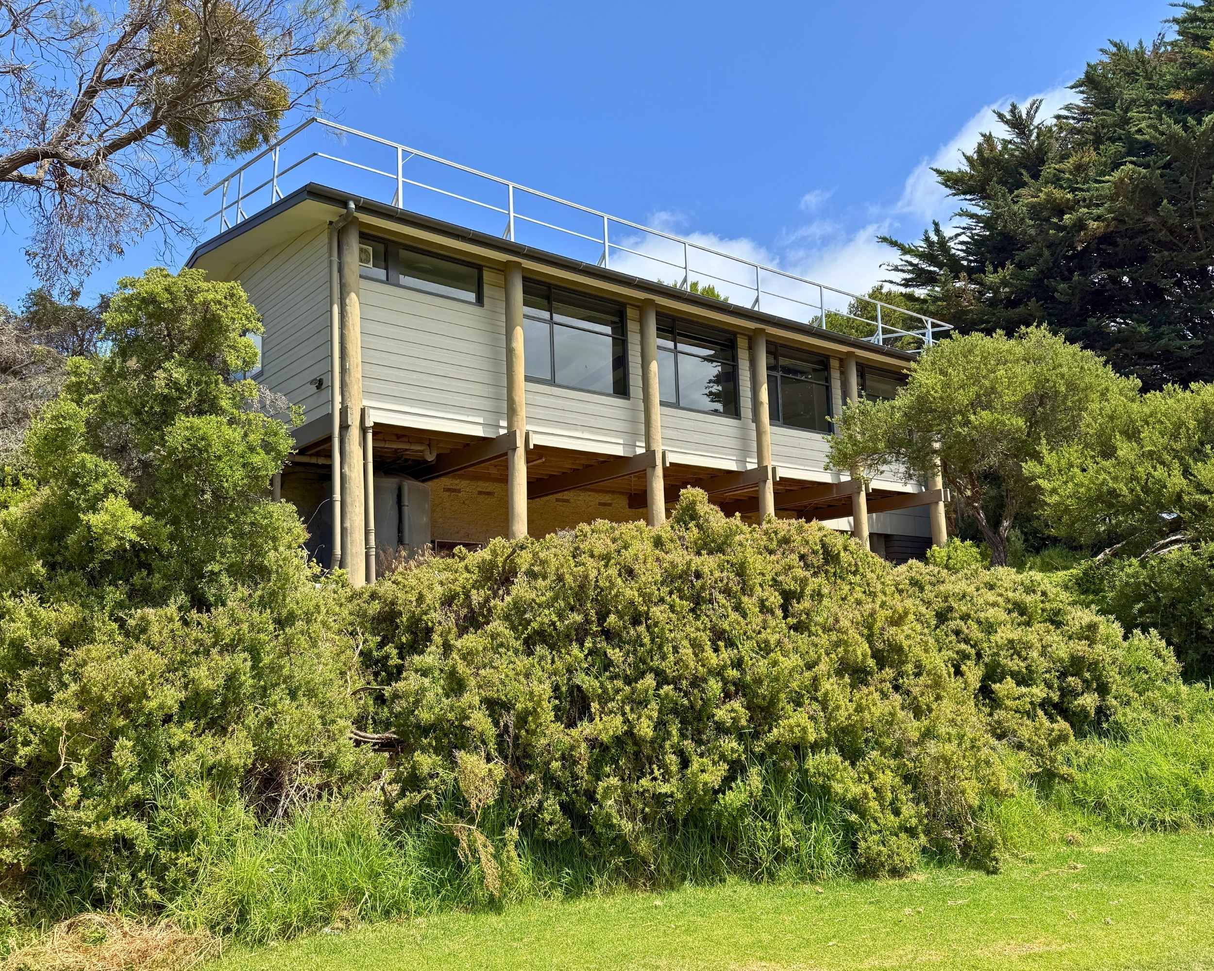 Elevated view of Watsons Pavilion nestled among trees, with open green space in the foreground