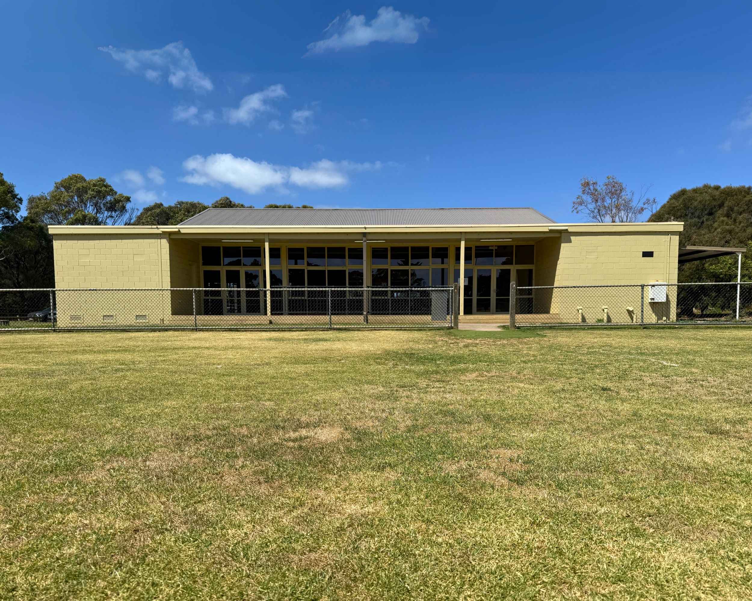 Boneo Community Hall exterior under blue skies, with wide lawn in the foreground.