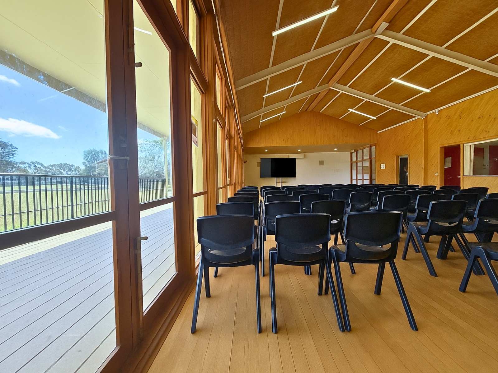 Side view of the seated hall, featuring full-length windows looking out to the open grounds.