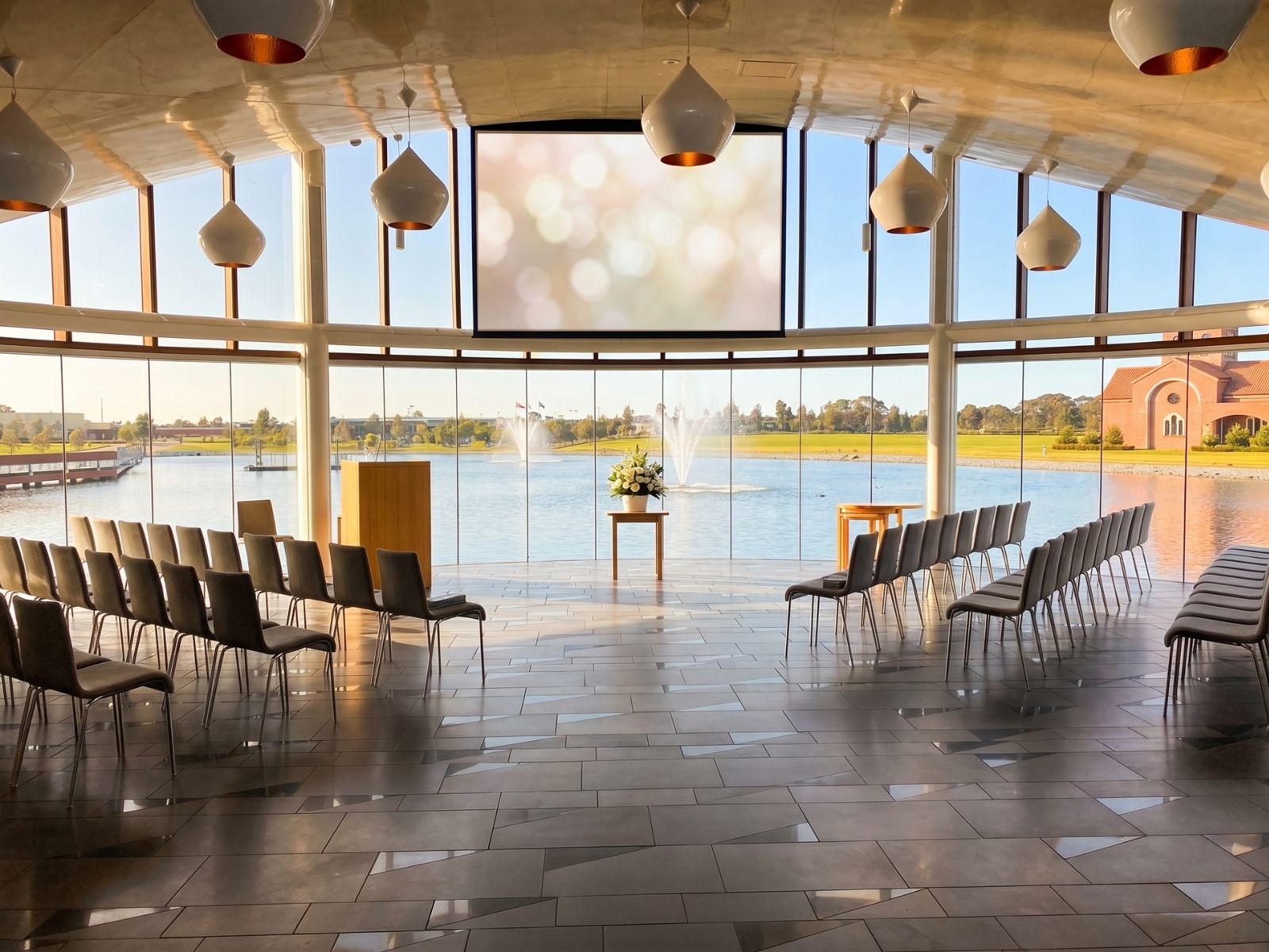 Sanctuary Chapel interior at Bunurong Memorial Park with panoramic lake views, chairs and projection screen