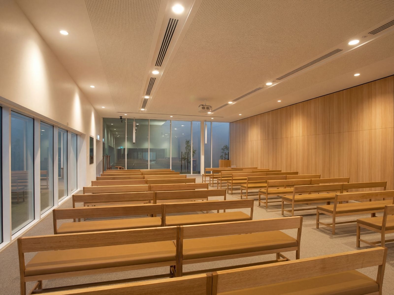 Timber pews and blond veneer feature wall inside Cumulus Chapel at Bunurong Memorial Park