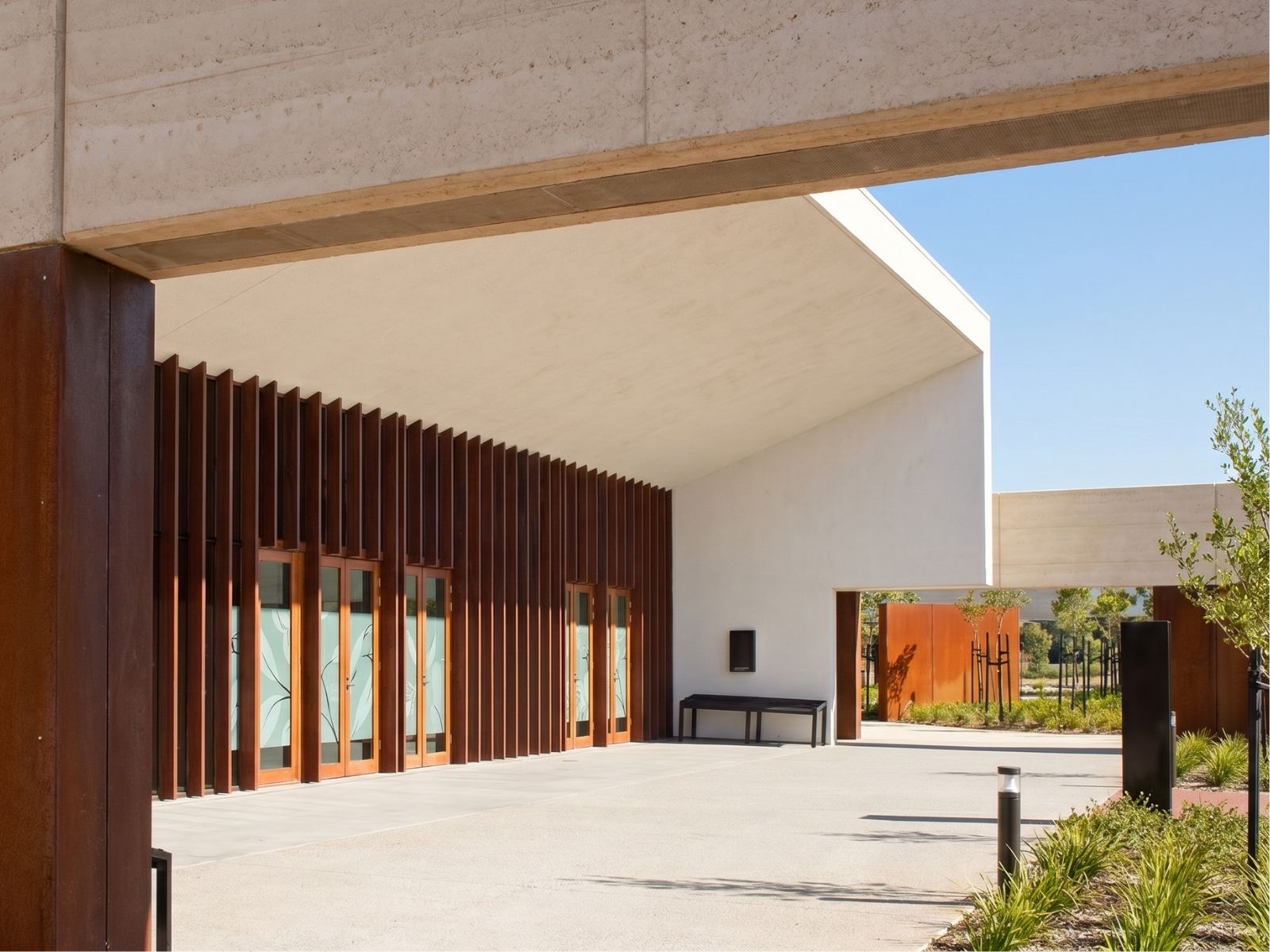 Covered entry at Stratus Chapel, Bunurong Memorial Park, with Corten fins, timber doors and drive-through canopy