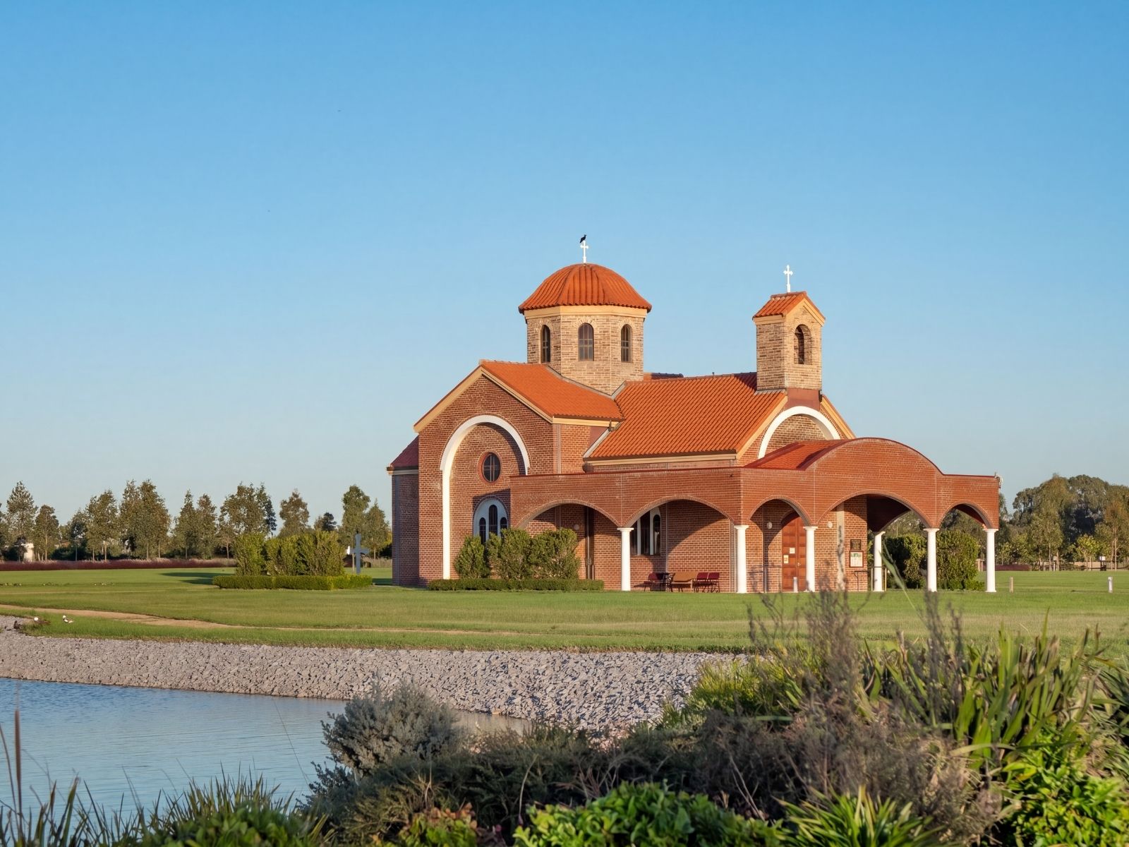 Exterior of Saint Lazarus Greek Orthodox Church at Bunurong Memorial Park, with its domed tower, bell tower and arched arcade