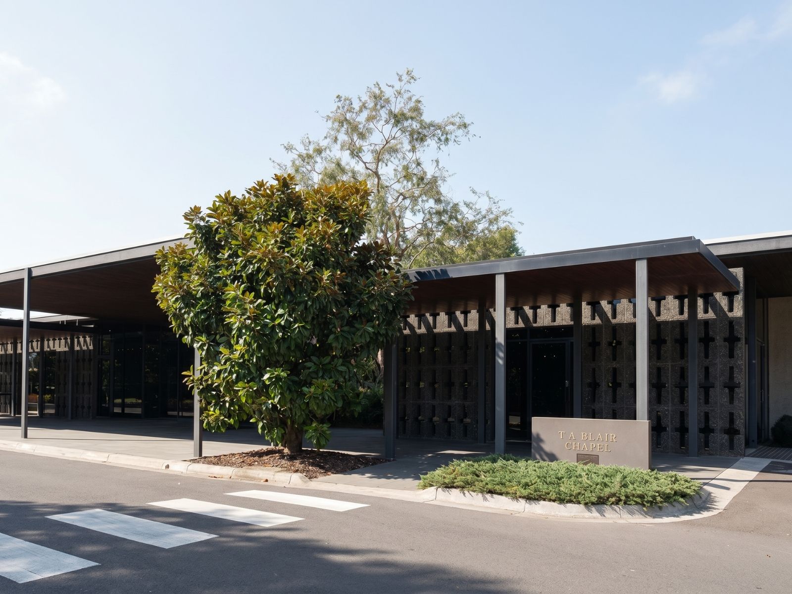 Blair Chapel exterior at Springvale, modernist pavilion with cross-patterned walls and magnolia tree at the entrance