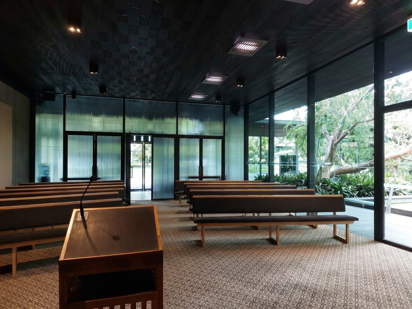 Blair Chapel interior looking towards the reeded glass entry wall, with garden views through full-height glazing