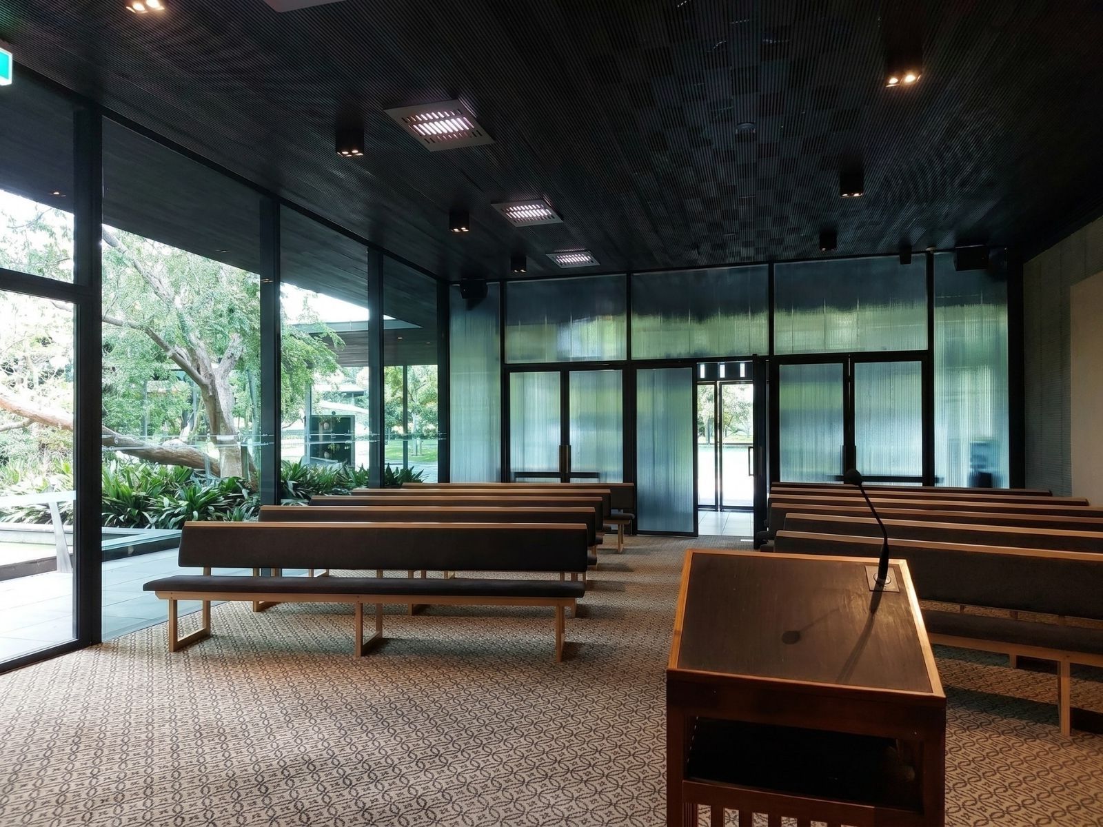Wilson Chapel interior looking towards the reeded glass entry wall, with garden views through full-height glazing
